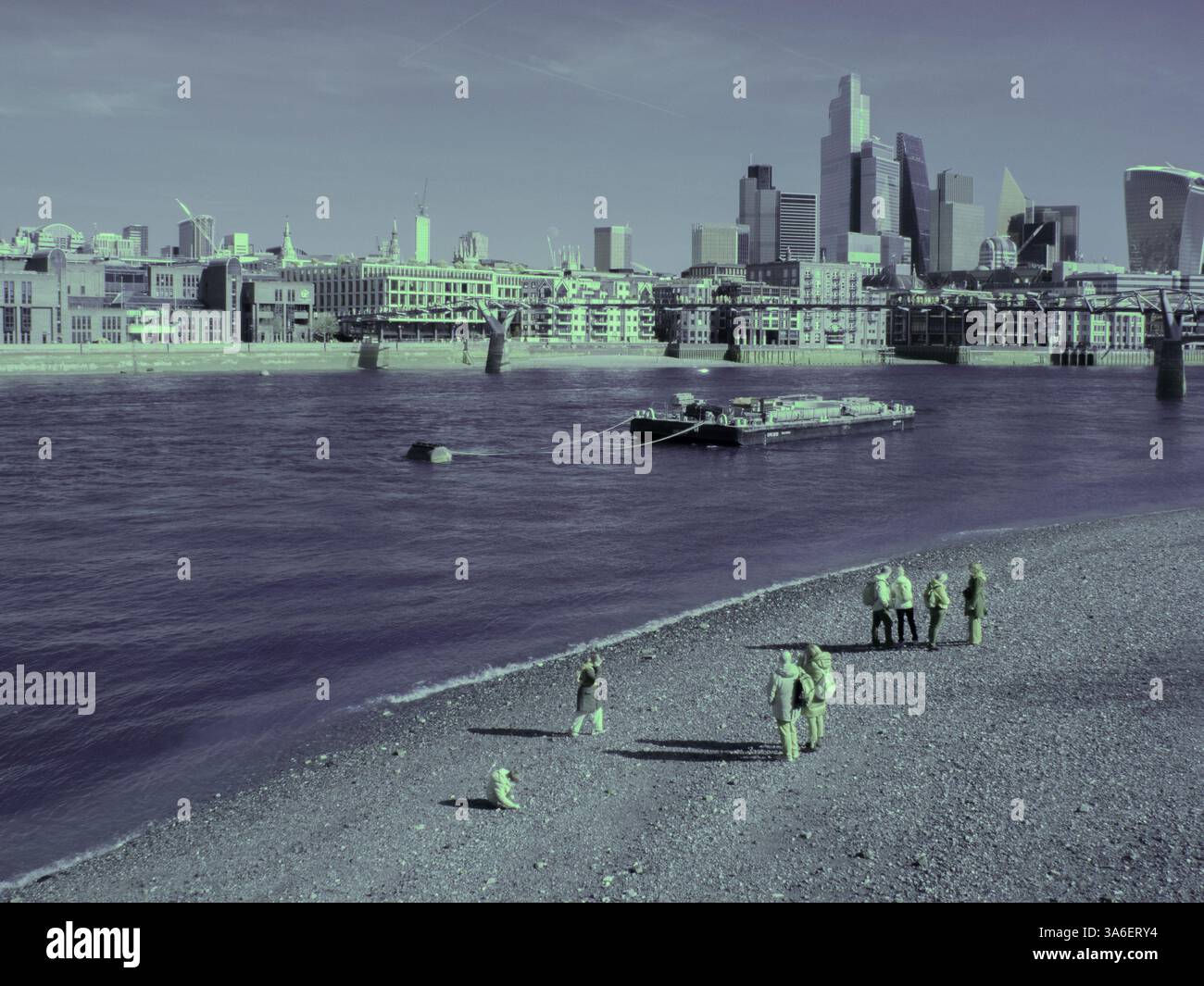 Les gens marchant le long de la rive sud de la Tamise à marée basse sur la plage de galets, image prise avec une caméra infrarouge convertie image 590 nm Banque D'Images