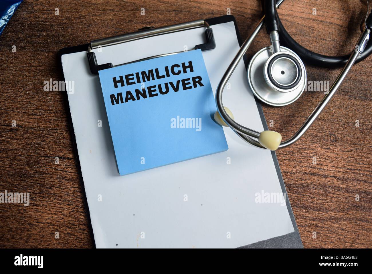 Concept de manœuvre Heimlich écrire sur des notes collantes isolées sur une table en bois. Banque D'Images