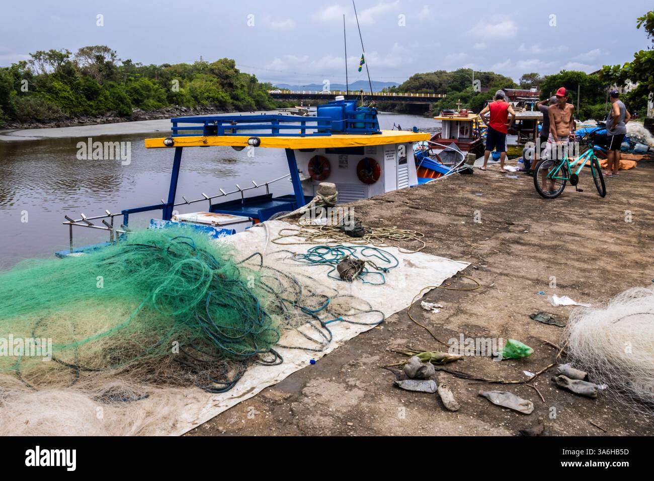 Peruibe, Sao Paulo, 17 janvier 2025. Scène de port de pêche à Peruíbe, état de Sao Paulo. Les filets colorés, les bateaux et la toile de fond de la forêt atlantique capturent t Banque D'Images
