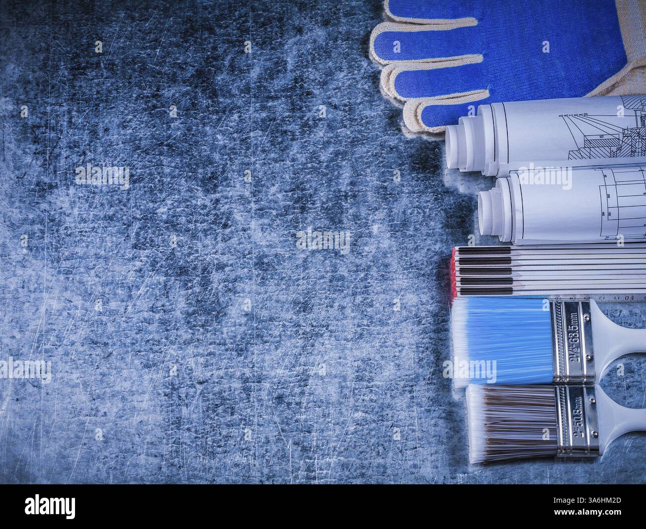 Copyspace de pinceaux de mètre en bois gants de protection et plans roulés Banque D'Images