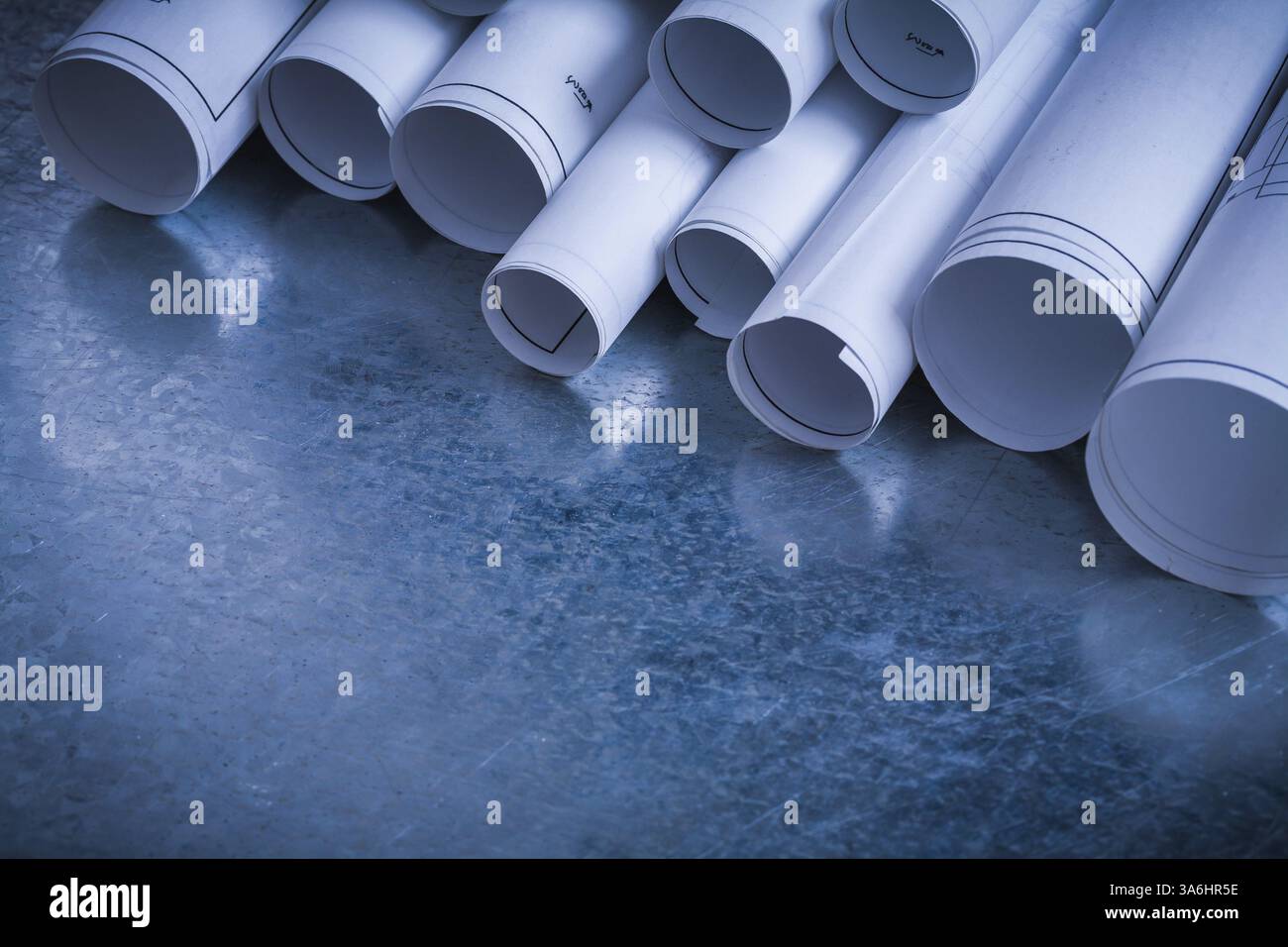 Rouleaux de plans de construction blancs sur fond métallique rayé bâtiment et concept d'architecture Banque D'Images