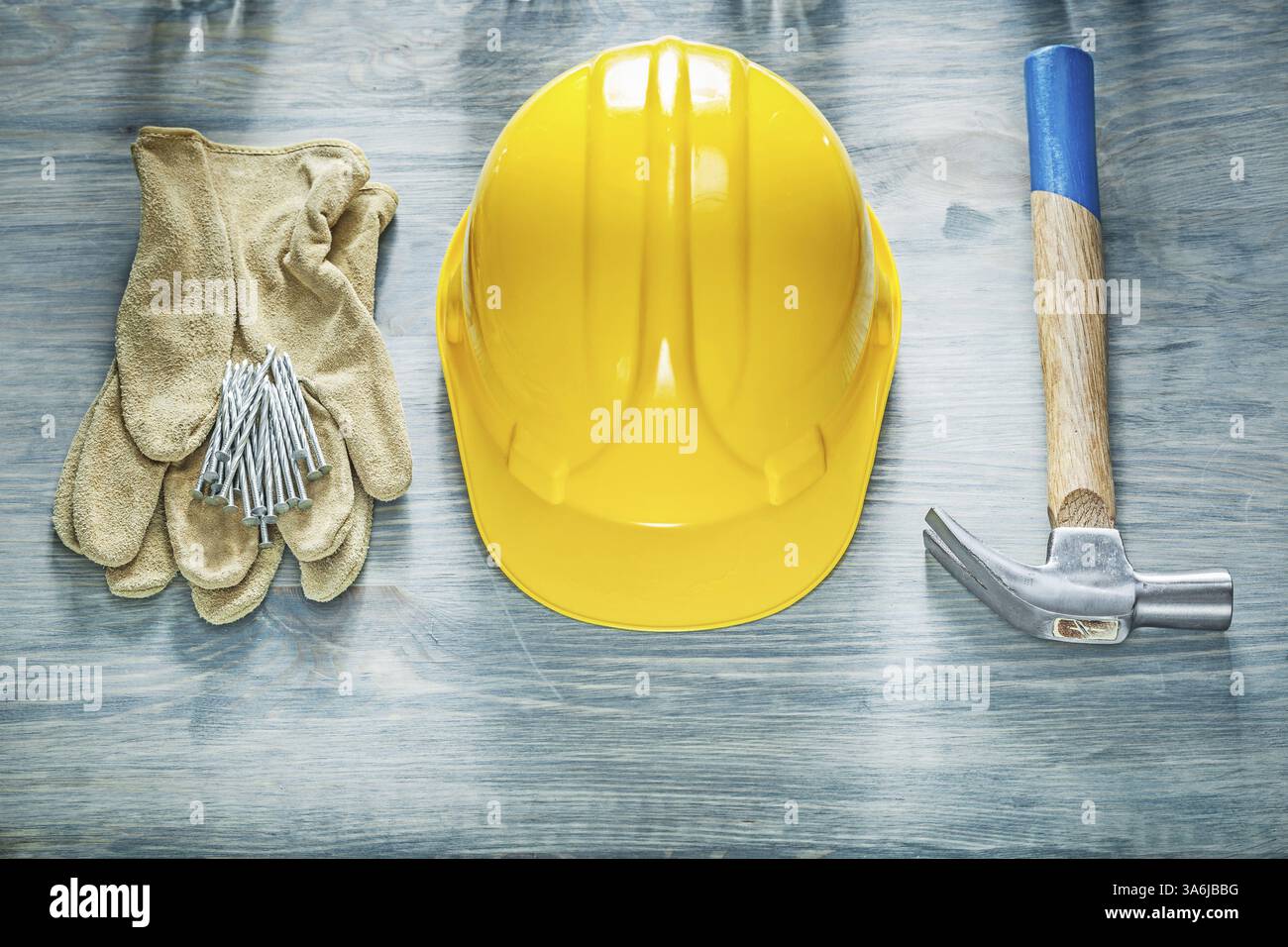Ensemble de gants de protection de casque de construction clous de marteau de griffe sur le concept de construction de panneau en bois Banque D'Images