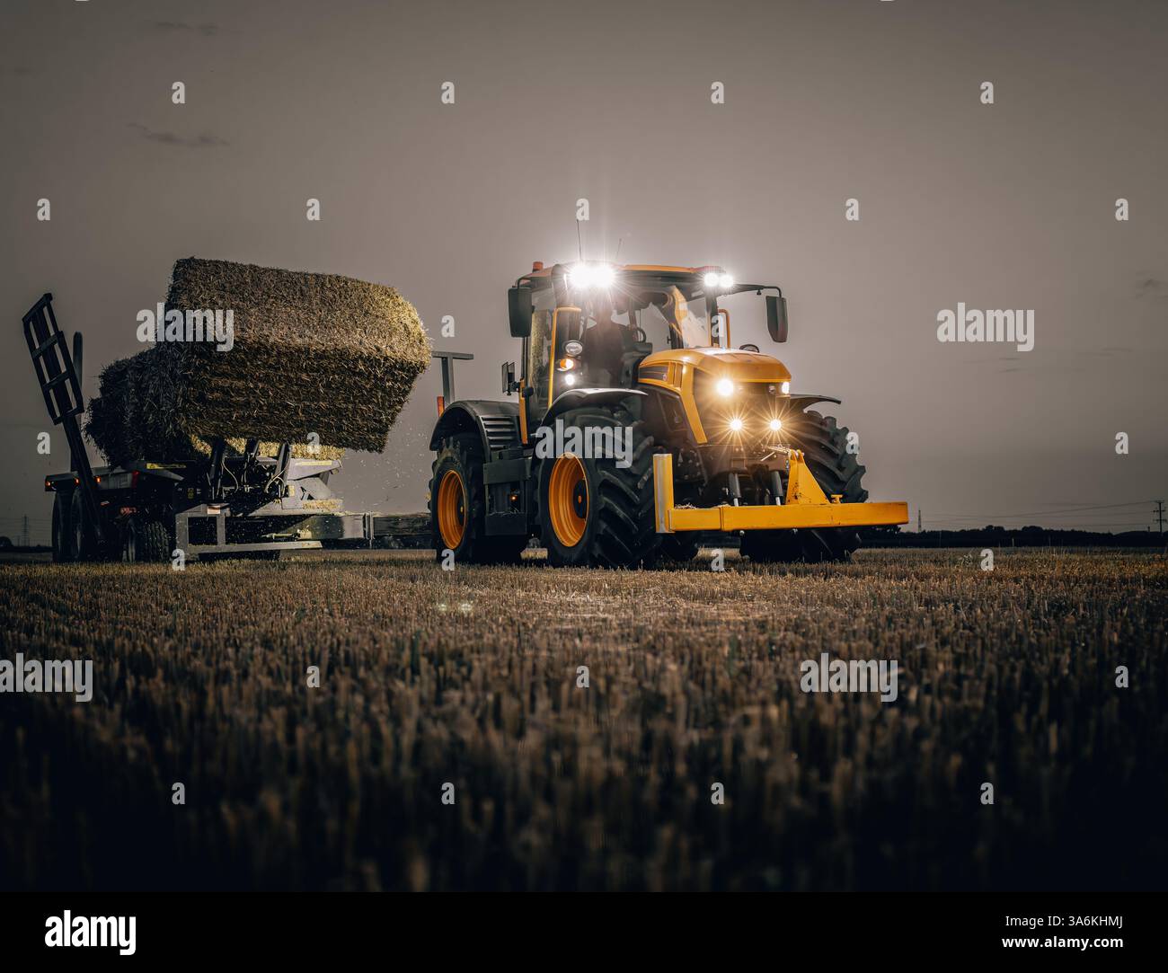Tracteur ramassant les balles pendant la récolte. Banque D'Images