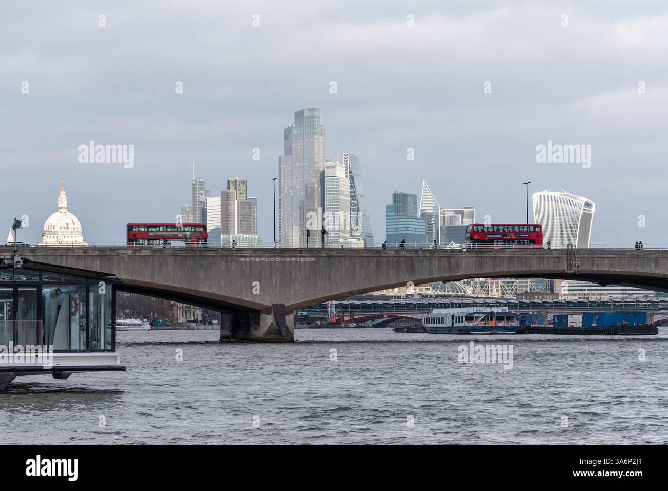 Bus rouges traversant le pont Waterloo sur la Tamise avec la ville de Londres vue depuis Victoria Embankment, Londres, Angleterre, Royaume-Uni Banque D'Images
