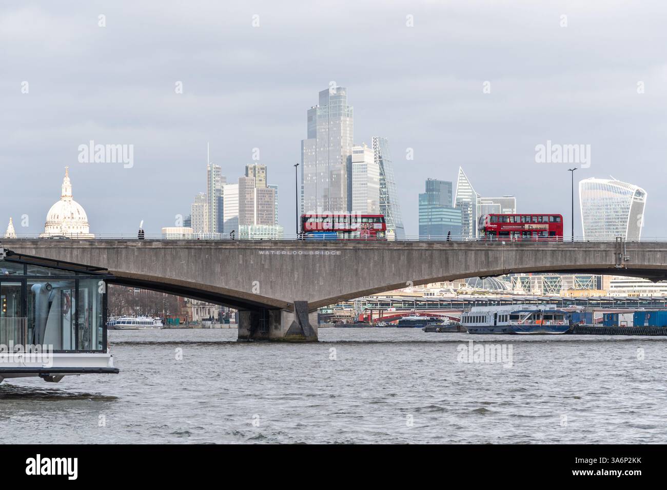 Bus rouges traversant le pont Waterloo sur la Tamise avec la ville de Londres vue depuis Victoria Embankment, Londres, Angleterre, Royaume-Uni Banque D'Images
