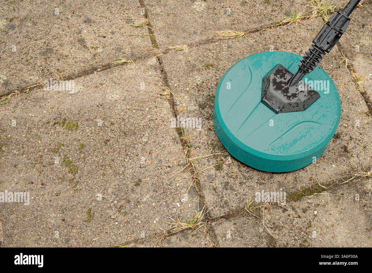 un nettoyeur haute pression rond nettoyant les vieilles dalles de béton sales Banque D'Images