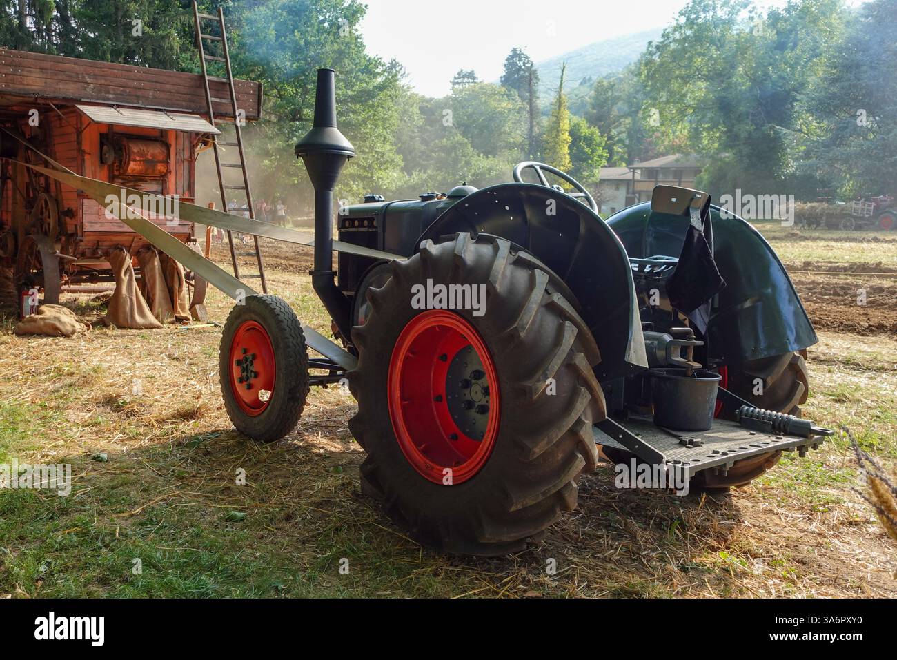 Tracteur d'époque alimentant une machine de battage Banque D'Images