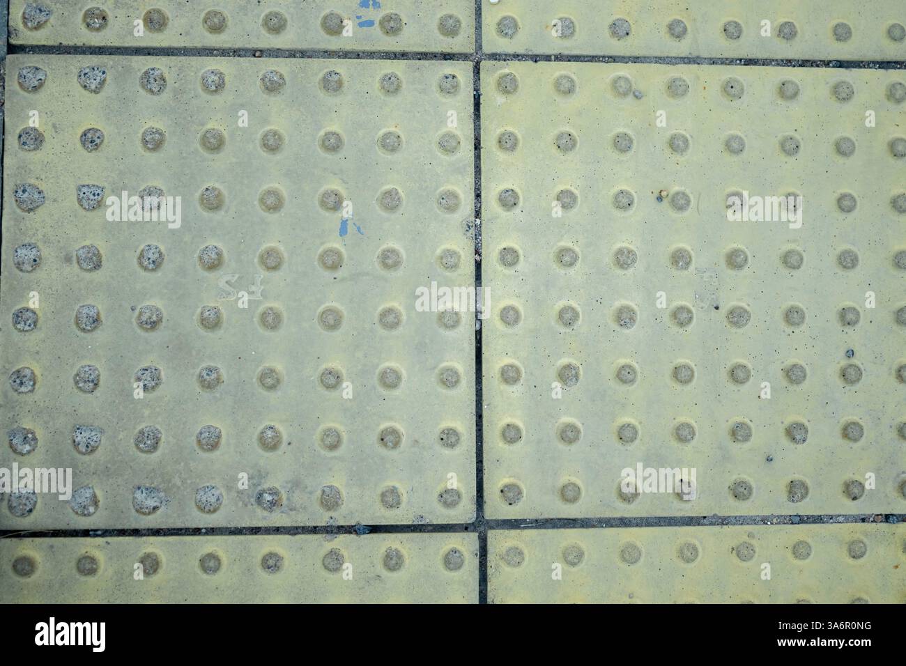 Floor Station indonésien. Motif. Gros plan des lignes jaunes et des blocs jaunes texturés dans les gares comme blocs de guidage ou trottoirs de routes aveugles pour Banque D'Images