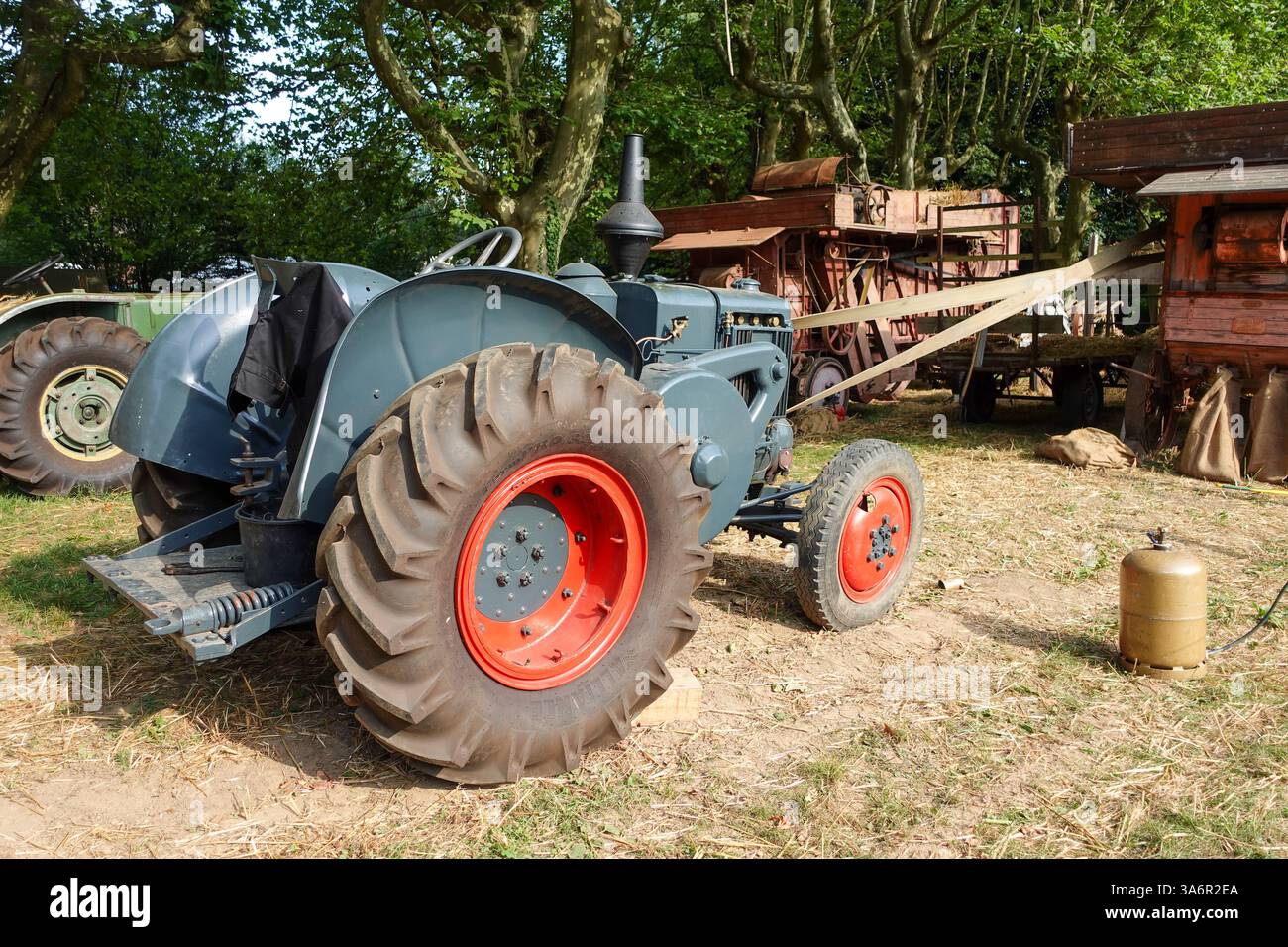 Tracteur d'époque alimentant une machine de battage Banque D'Images