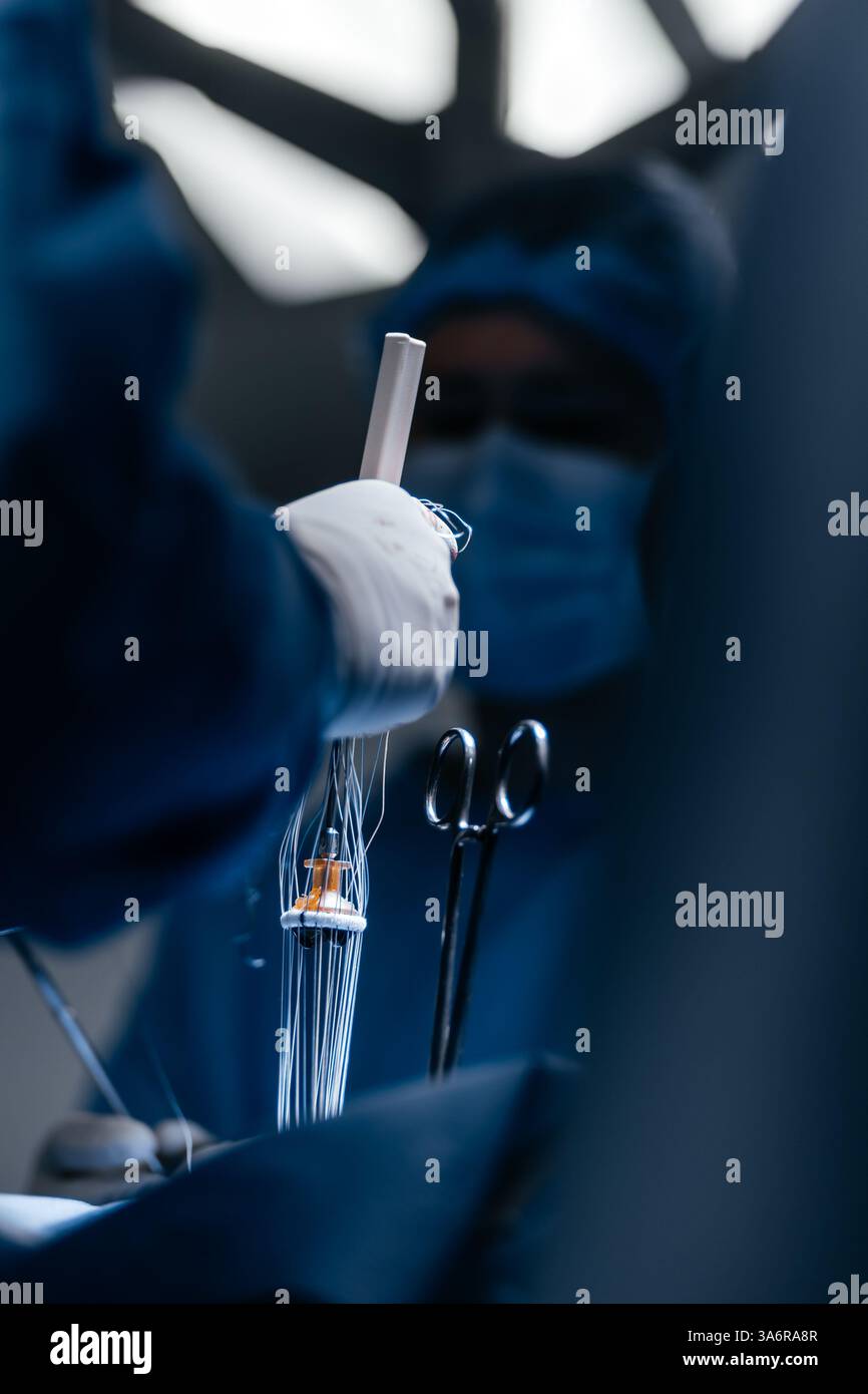 Chirurgien pratiquant une opération cardiaque à pleine concentration dans une salle d'opération bien éclairée. Médecin professionnel. Technologies, cardiologie. Banque D'Images
