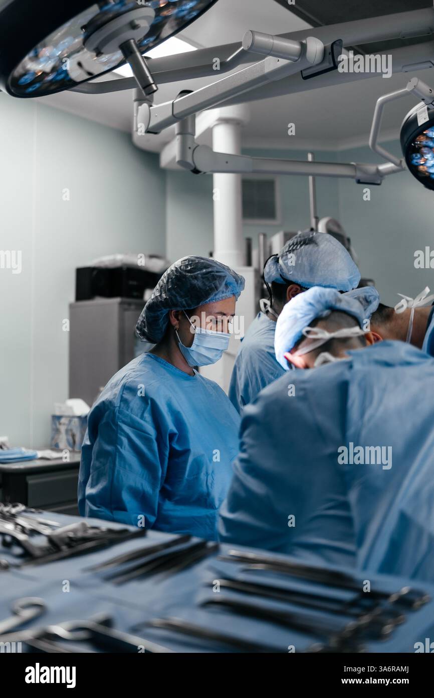 L'équipe de chirurgie opérant dans l'hôpital moderne. Les travailleurs médicaux travaillent en équipe, sauvant la vie du patient en sauvant la chirurgie plastique cardio. Concept de médecine Banque D'Images