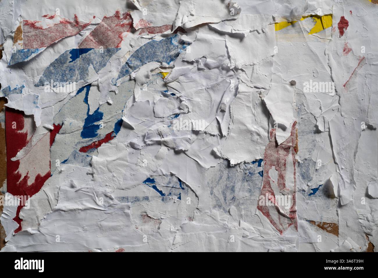 Texture murale sale avec du papier pelé blanc, rouge, bleu et jaune Banque D'Images