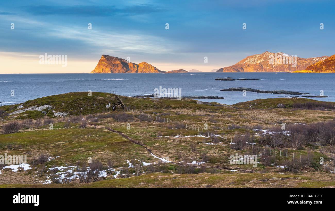 Coucher de soleil sur la rive de l'Atlantique Nord. Maisons de vacances en bois sur les îles de Hillesøy et Sommarøy. rivage pierreux avec maison rouge et jaune Banque D'Images