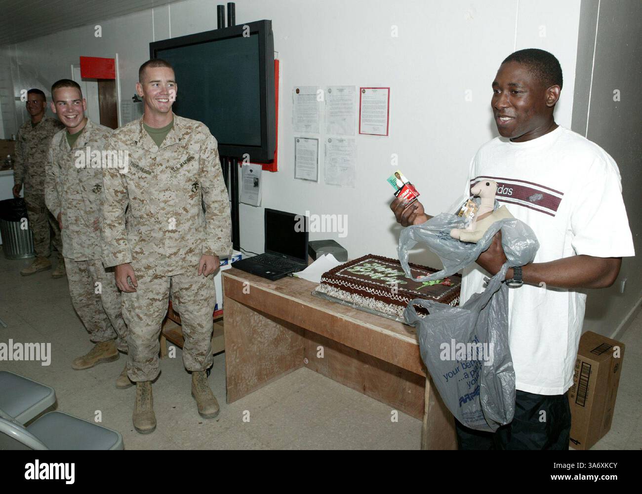 Le 10 juillet 2004 ; Al Asad, Irak ; le Cpl CHRISTOPHER D. THORDARSON (au centre), électricien, MTACS-38, et âgé de 21 ans, a choisi Cloud, Minn., natif, lance Cpl. WILLIAM T. PIERE (au premier plan à gauche), spécialiste de la logistique et de l'embarquement, MTACS-38, lors de la célébration mensuelle de l'anniversaire MTACS-38 à Al Asad, Irak, le 10 juillet. Djadoo, un 27 ans de Minneapolis, était l'un des six Marines de l'unité à être reconnu lors de la célébration pour avoir eu un anniversaire au mois de juillet. Banque D'Images