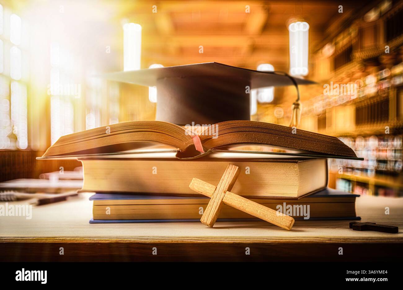 Études et diplômé religieux avec pile de livres avec Bible et mortarboard sur le dessus sur le bureau en bois avec croix religieuse et fond d'une salle de classe Banque D'Images