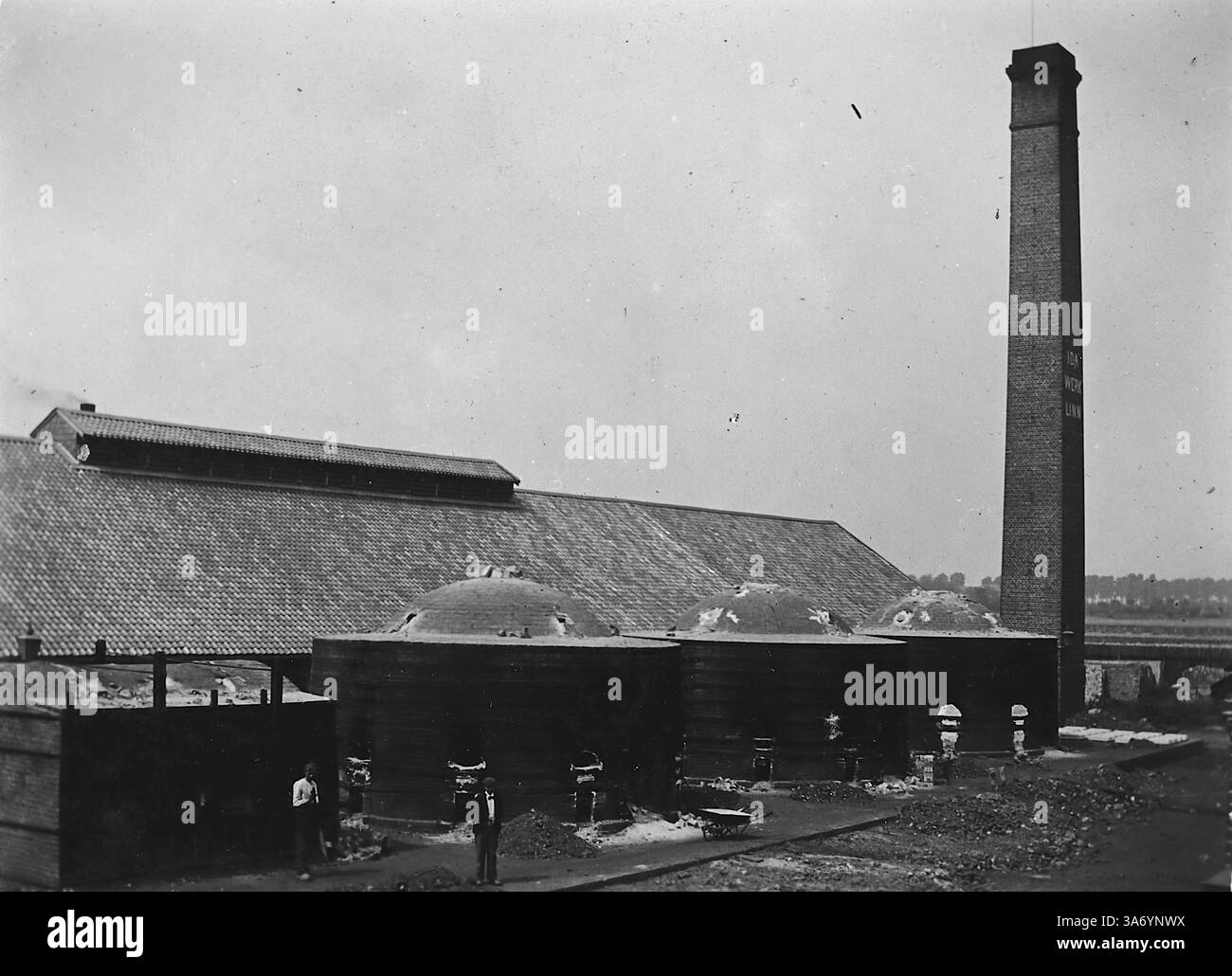 IDA Werk, Ganister Brick travaille à Linn, un quartier historique de la ville de Krefeld, situé dans l'état de Rhénanie du Nord-Westphalie, Allemagne. Cette image montre des ouvriers à côté des fours et une grande cheminée industrielle. D’après une collection de photographies d’une tournée européenne familiale qui s’est déroulée en 1899. Les photographies originales étaient d'environ 3 ½ x 2 ½ pouces et présentent une vue intéressante des coutumes, des modes et de l'histoire sociale de la fin de la période victorienne. Banque D'Images