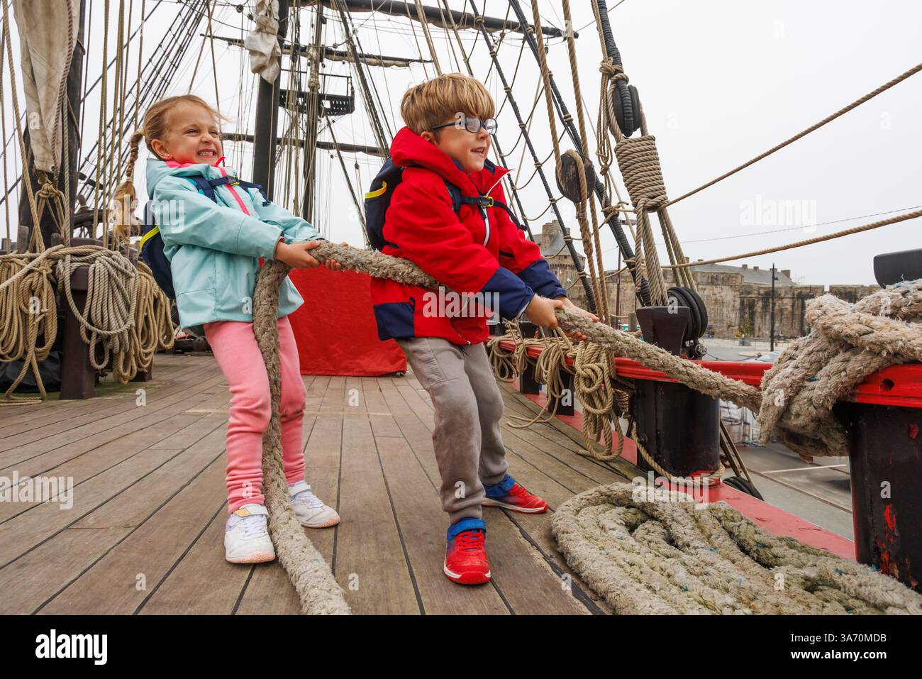 Les enfants tirent joyeusement une corde sur l'attraction aventure du pont de bateau Banque D'Images