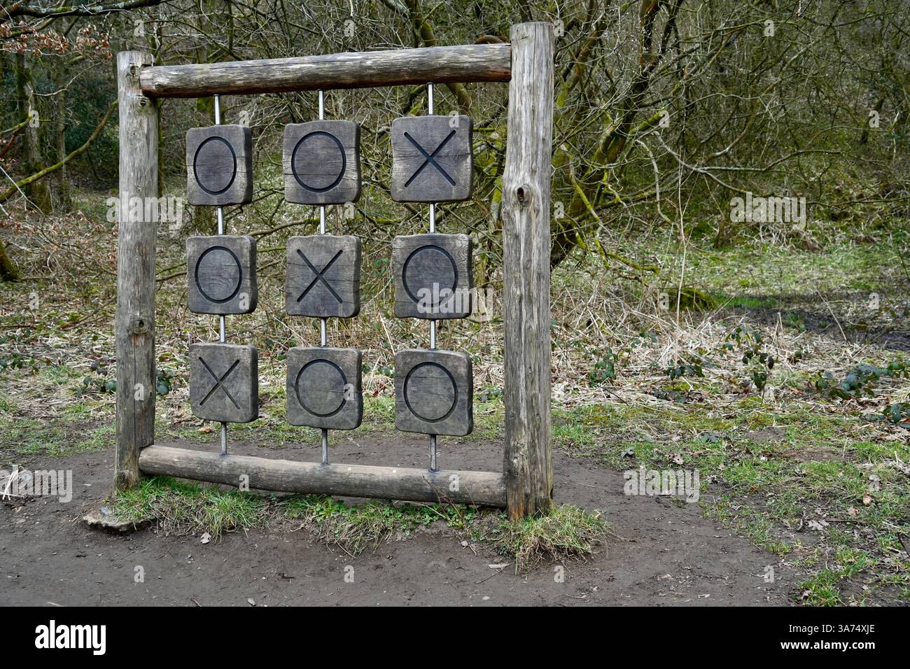Un grand jeu de noughts et de croix en bois dans un emplacement forestier. Banque D'Images