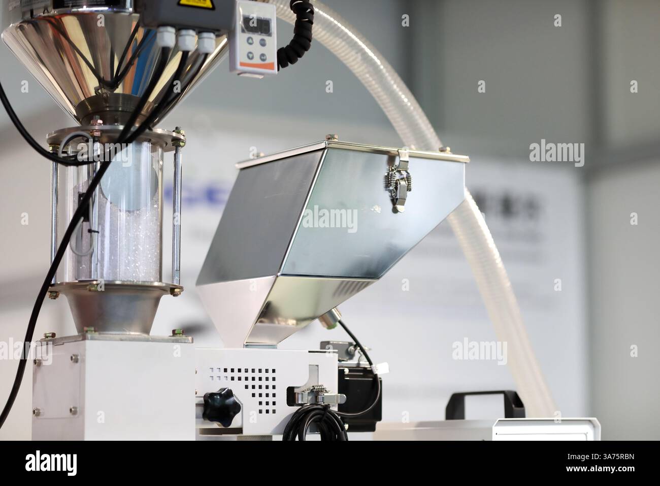 Trémie d'alimentation avec granulés de plastique brut et mélangeur de dose monocouleur. Pièces de machine de moulage par injection de matière plastique. Mise au point sélective. Banque D'Images