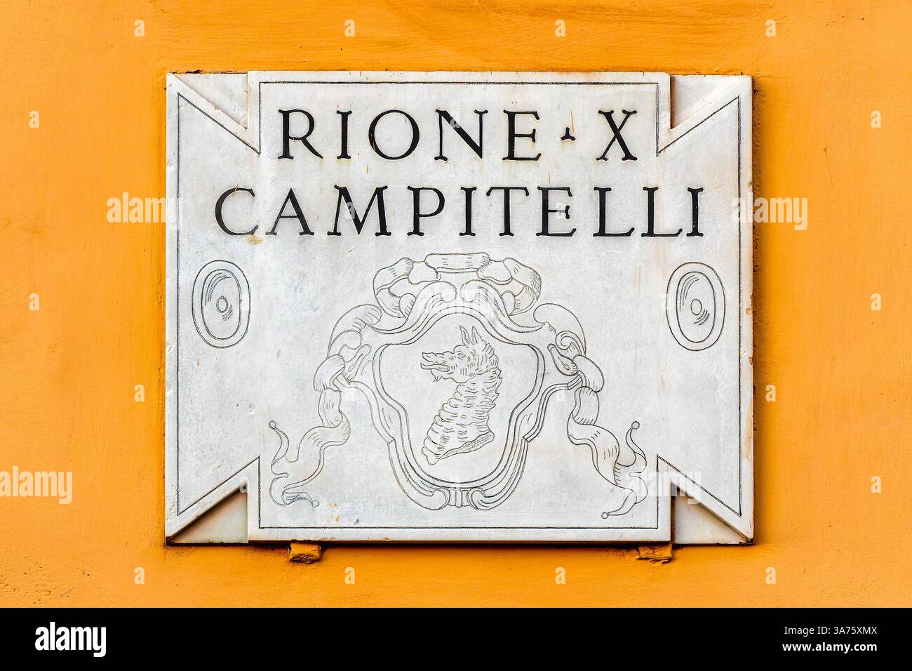 La plaque de marbre de Rione Campitelli à Rome, Latium, Italie, présente une tête de dragon noir sur fond blanc. Banque D'Images