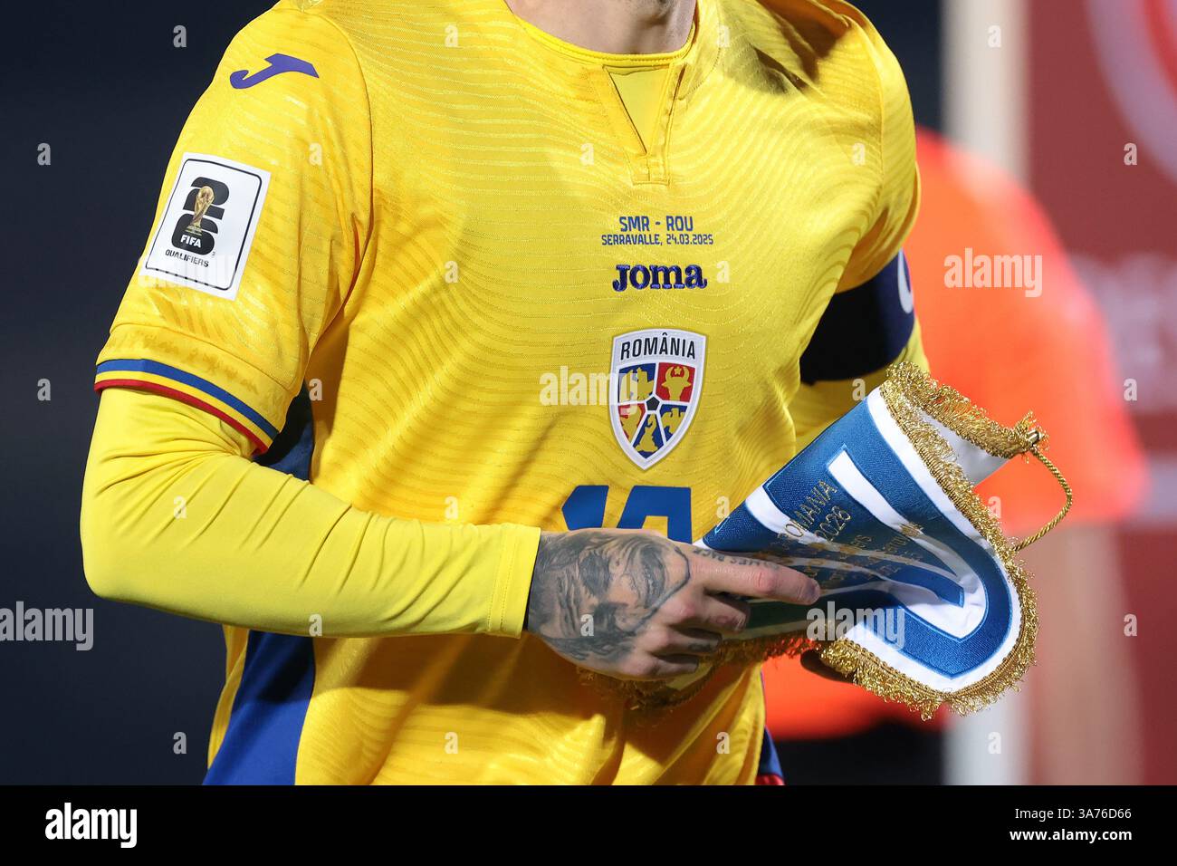 Serravalle, Italie. 24 mars 2025. Un tatouage sur la main de Nicolae Stanciu de Roumanie est vu alors qu'il donne le fanion de Saint-Marin à un membre du staff avant le coup d'envoi du match de qualification pour le Championnat d'Europe de l'UEFA au stade de Saint-Marin, Serravalle. Le crédit photo devrait se lire : Jonathan Moscrop/Sportimage crédit : Sportimage Ltd/Alamy Live News Banque D'Images