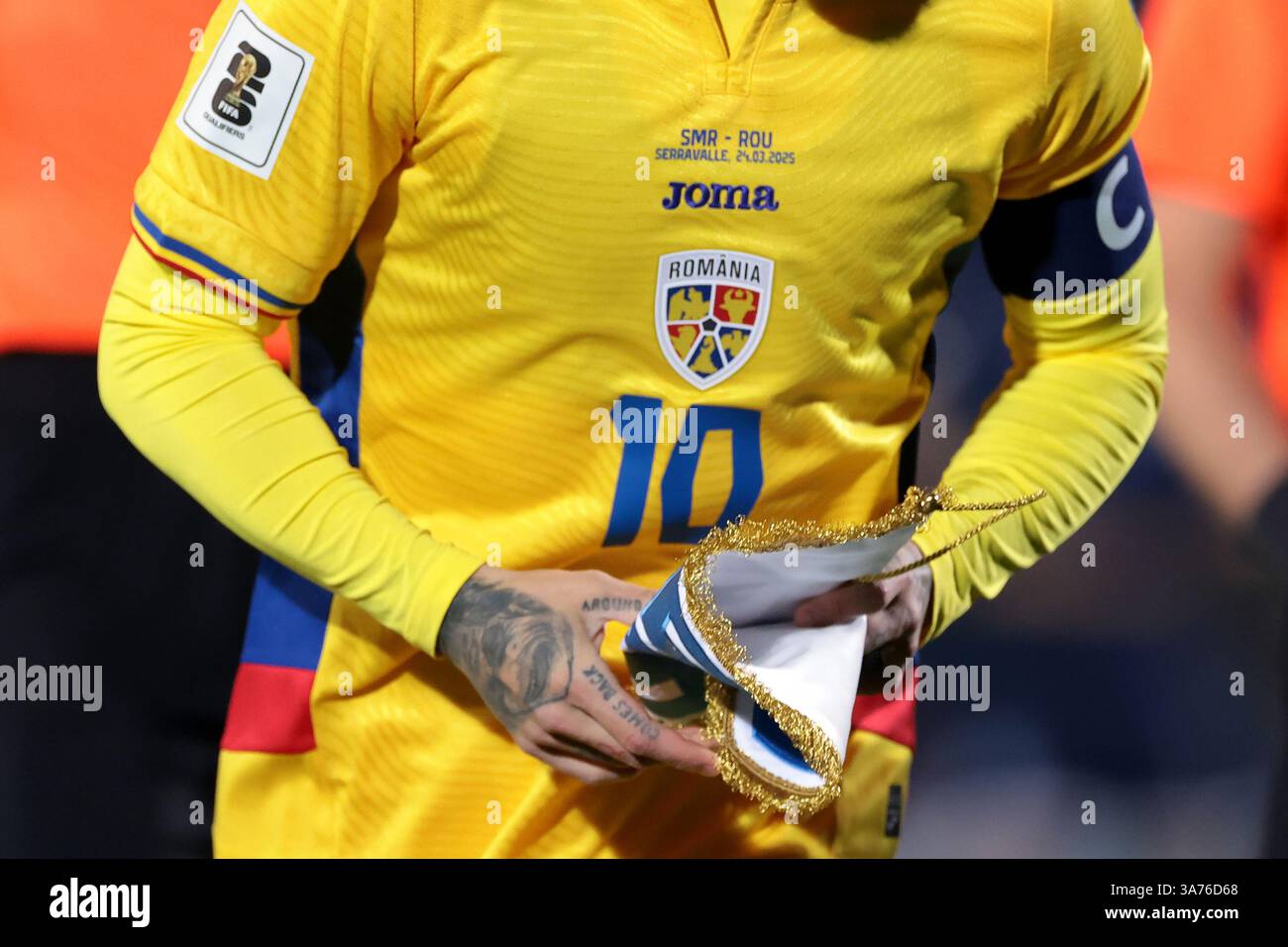 Serravalle, Italie. 24 mars 2025. Un tatouage sur la main de Nicolae Stanciu de Roumanie est vu alors qu'il donne le fanion de Saint-Marin à un membre du staff avant le coup d'envoi du match de qualification pour le Championnat d'Europe de l'UEFA au stade de Saint-Marin, Serravalle. Le crédit photo devrait se lire : Jonathan Moscrop/Sportimage crédit : Sportimage Ltd/Alamy Live News Banque D'Images