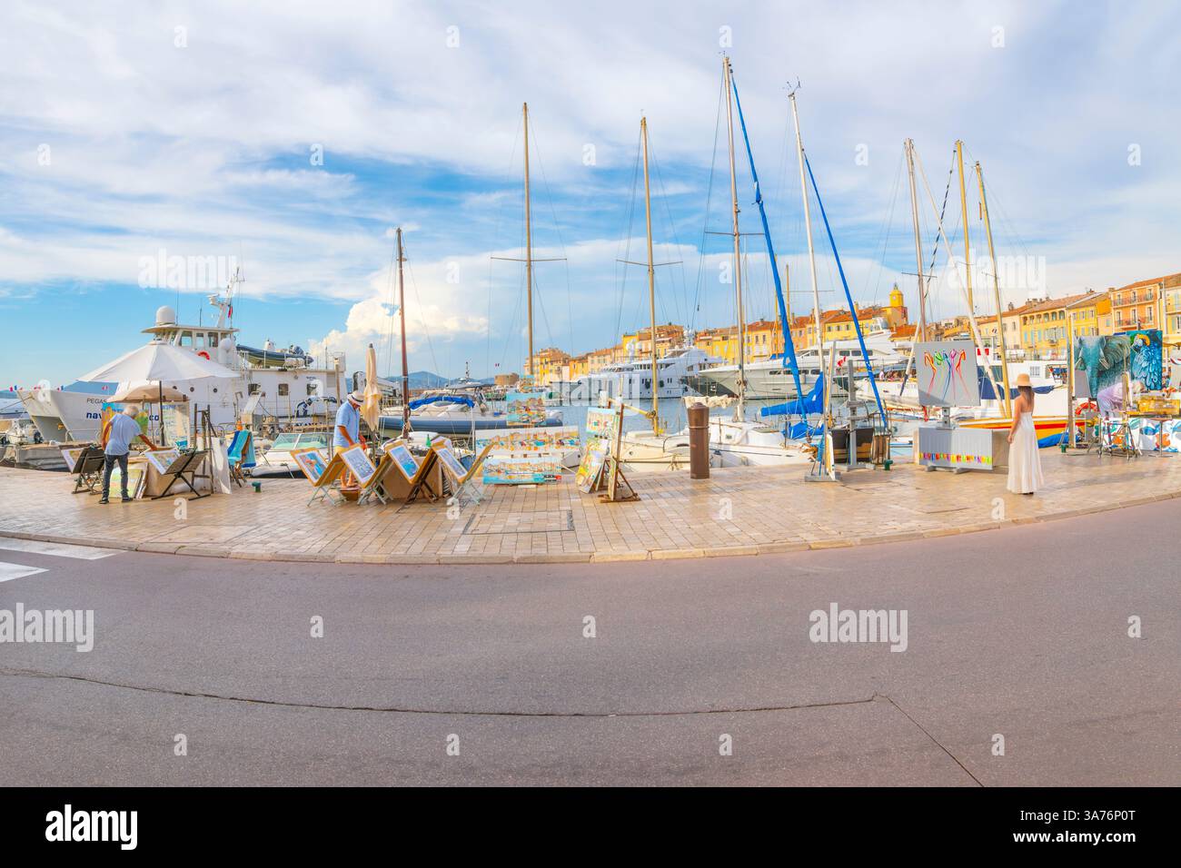 Voiliers et yachts de luxe bordent la marina colorée remplie de boutiques, d'art de rue et de cafés en bord de mer à Saint-Tropez, en France, une station balnéaire populaire. Banque D'Images
