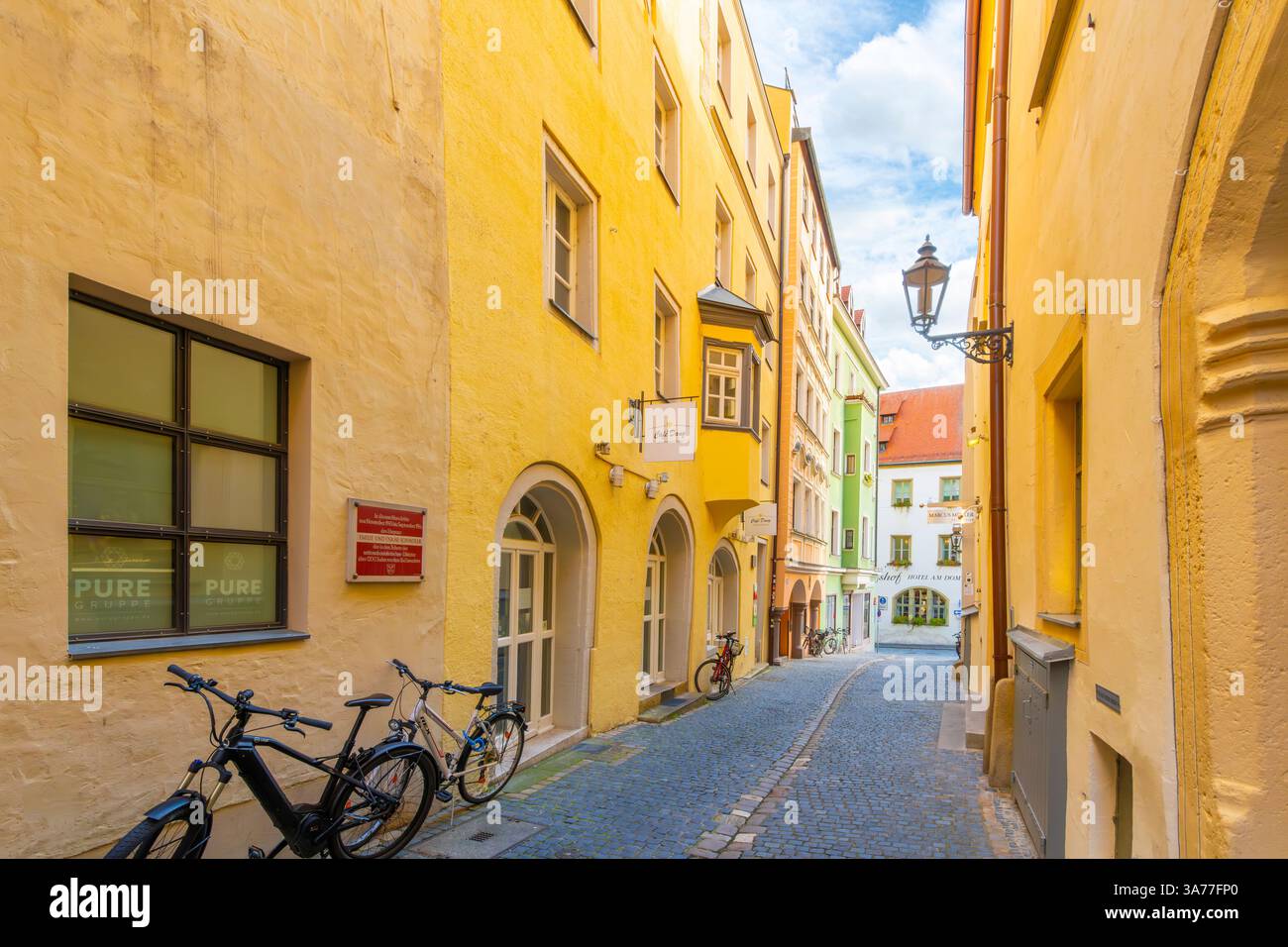 Une allée colorée de magasins à côté de la maison Oskar Schindler dans le quartier médiéval historique d'altstadt de la ville bavaroise de Ratisbonne, en Allemagne. Banque D'Images