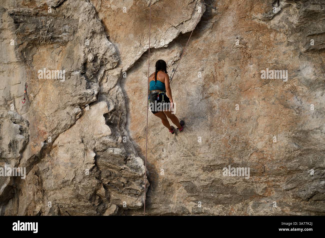 Grimpeur repose sur la corde à mi-chemin sur un mur de calcaire à Tonsai Banque D'Images