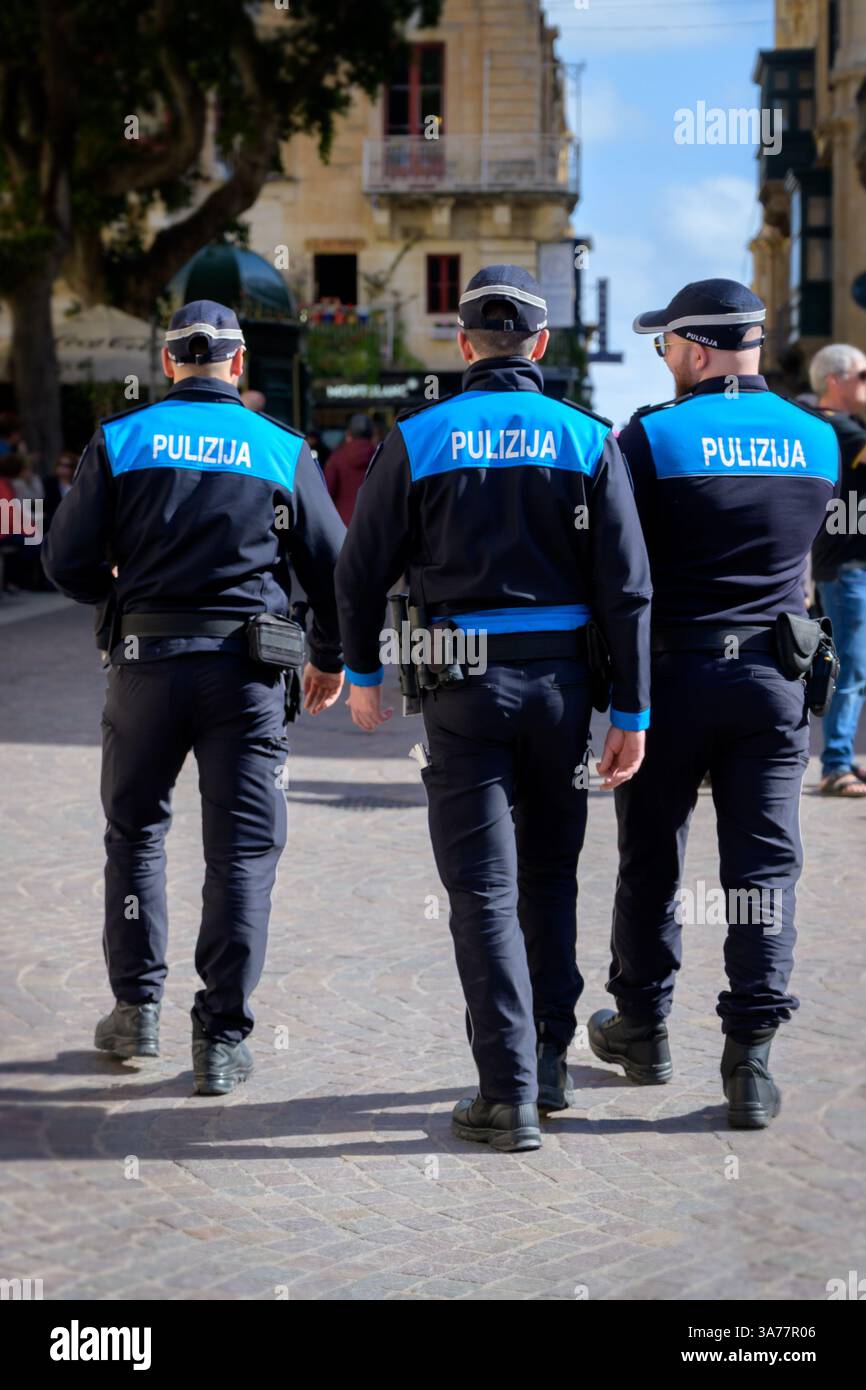 Image verticale trois officiers de police de Malte police force il-Korp tal-Pulizija ta’ Malta en uniforme en patrouille dans la rue de la Valette, Malte. Banque D'Images