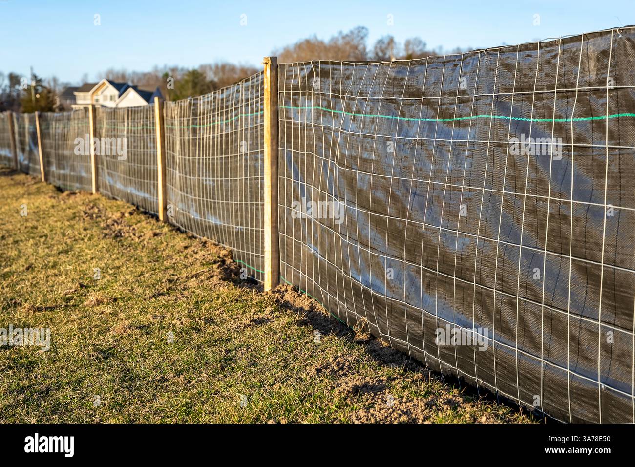 Tissu de clôture de limon avec treillis métallique et poteaux en bois installés avant le début de la construction. Banque D'Images