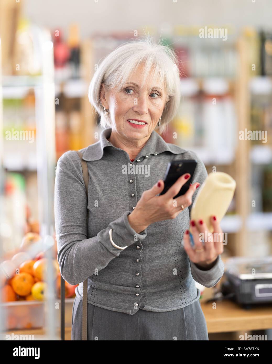 Femme âgée scannant le code qr pour la mayonnaise Banque D'Images