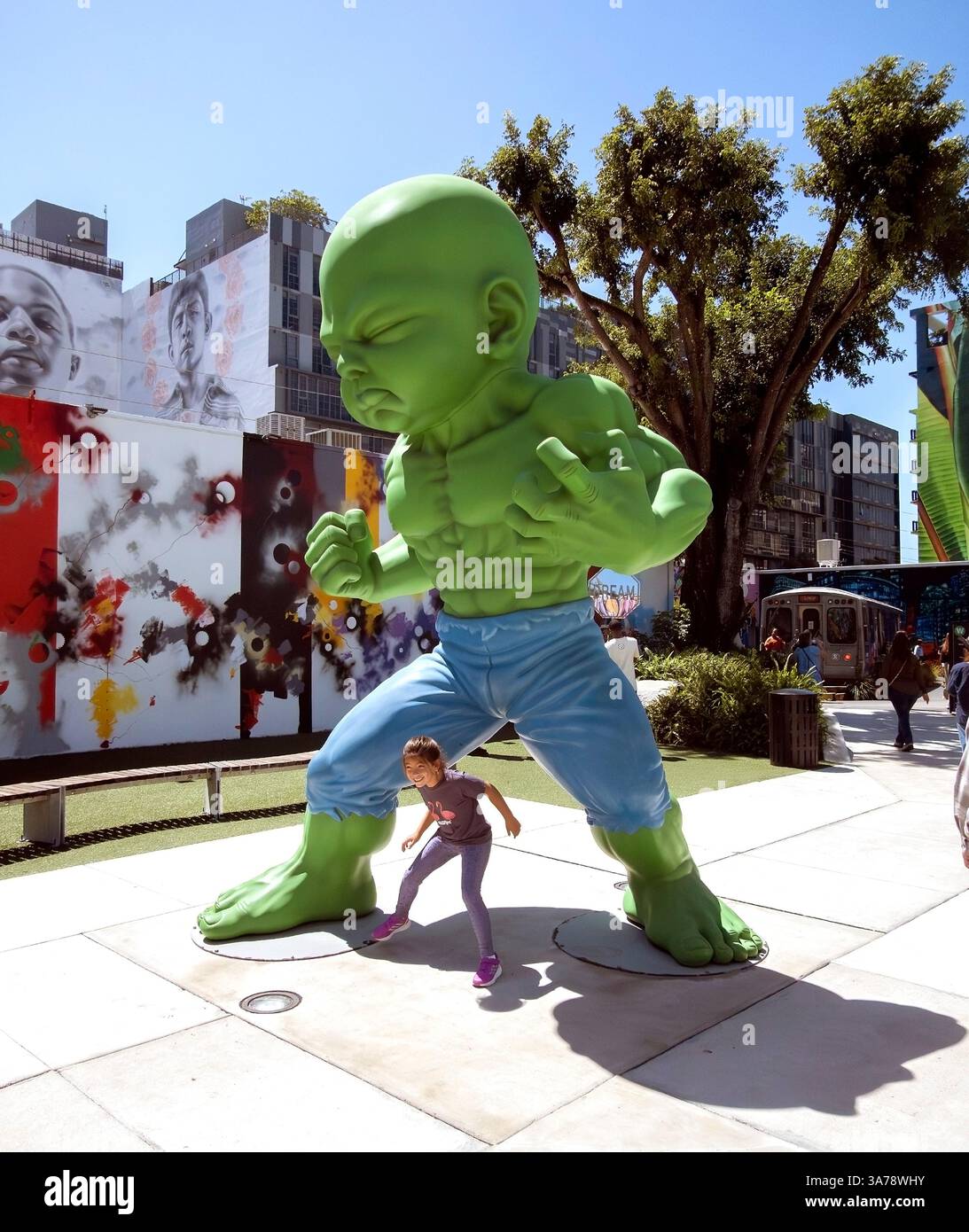 Fille pose sous une statue à Wynnwood Walls, Miami, Floride Banque D'Images