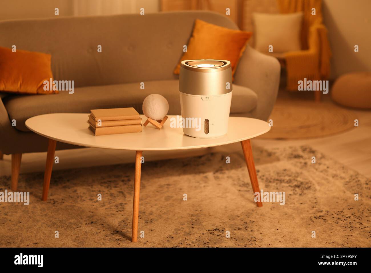 Humidificateur moderne sur table basse dans le salon le soir Banque D'Images