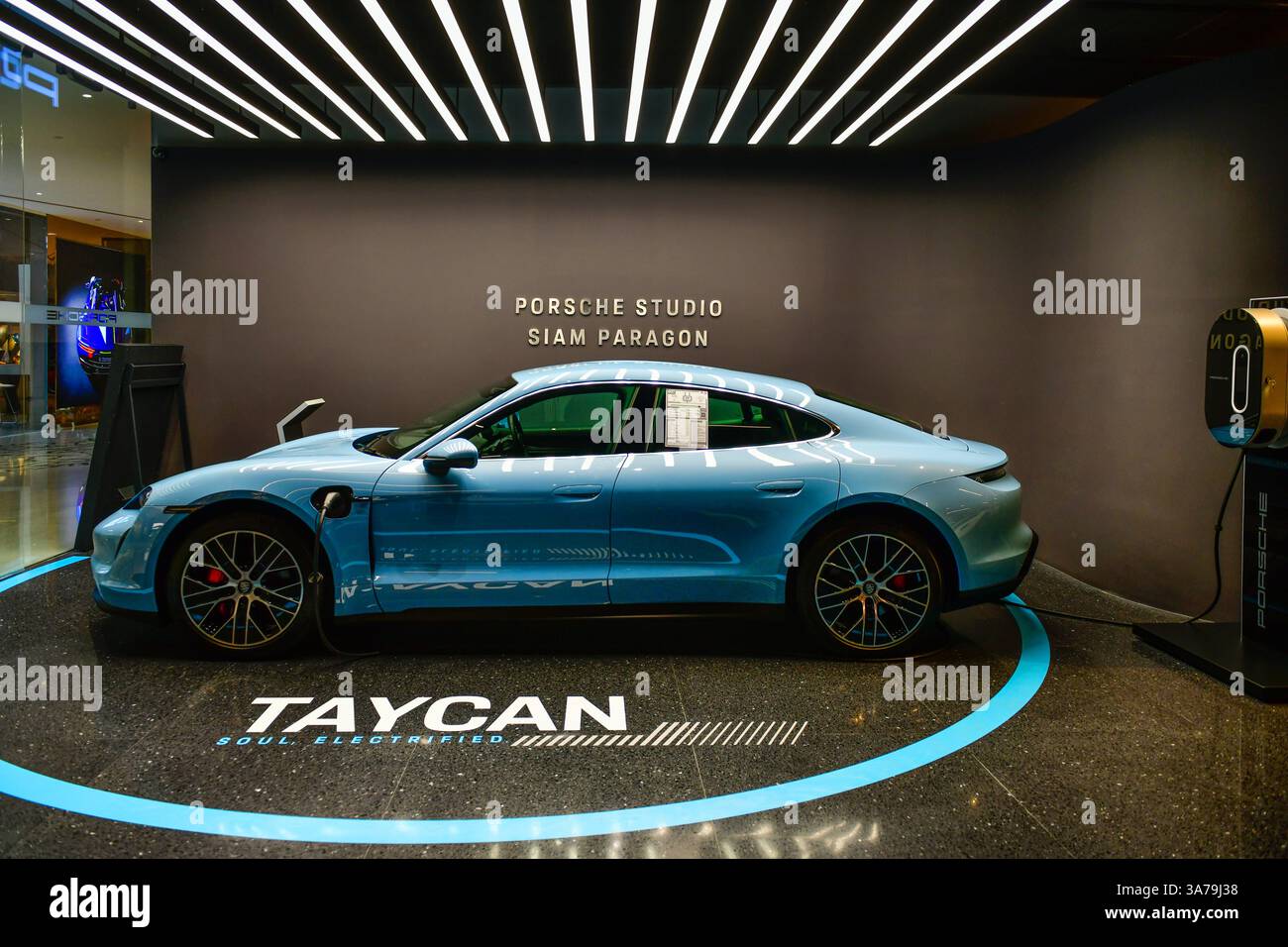BANGKOK, THAÏLANDE, -24 mars 2025 : Porsche Taycan haute performance voiture de sport électrique ultramoderne technologie dans la salle d'exposition, siam paragon Banque D'Images