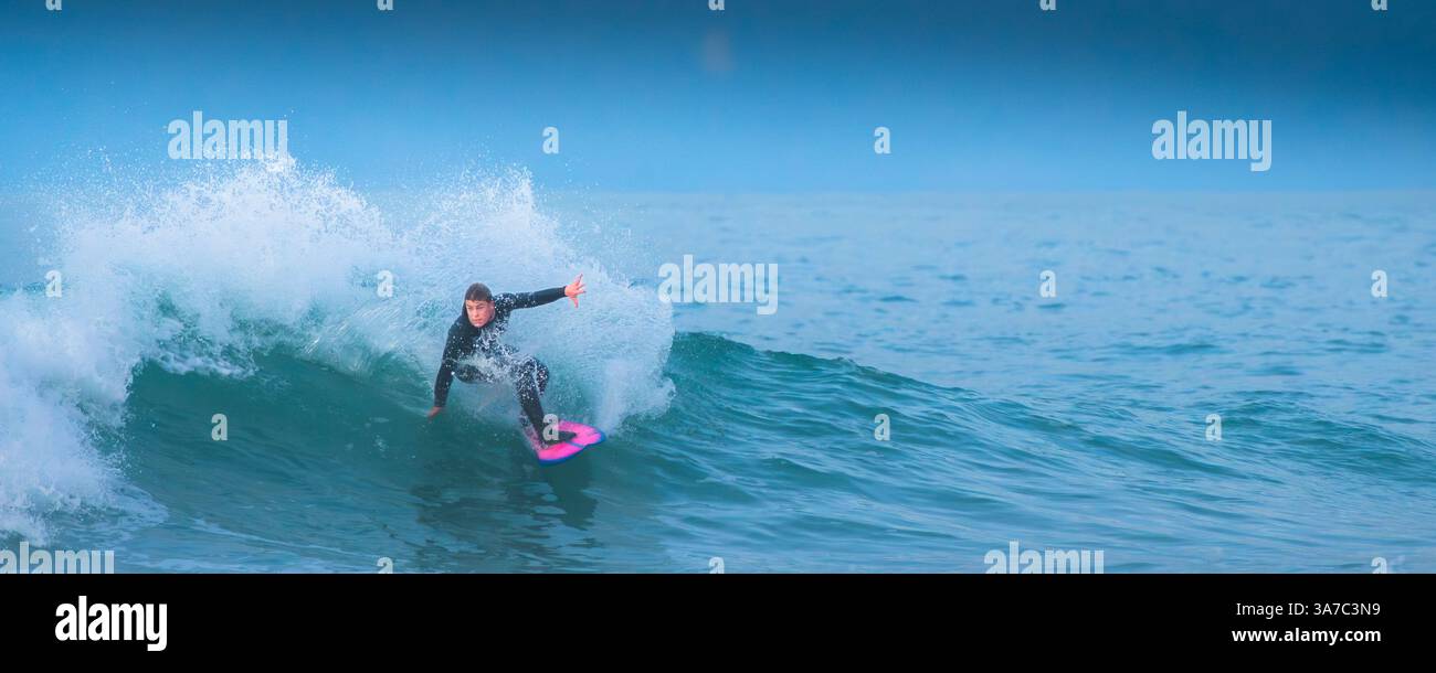 Image panoramique d'un surfeur qui fait une vague à Fistral à Newquay, en Cornouailles, au Royaume-Uni. Banque D'Images