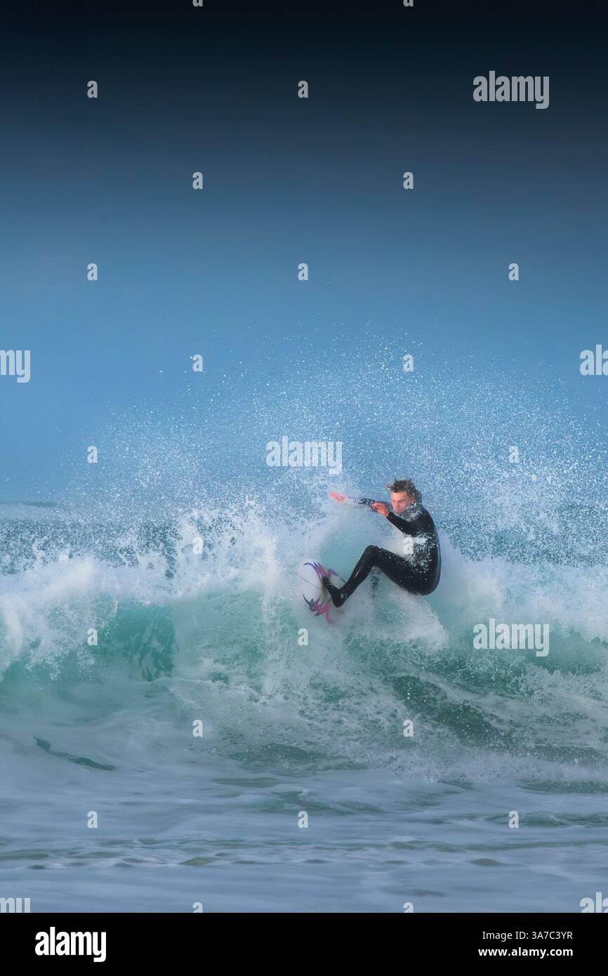Un surfeur qui fait une vague à Fistral à Newquay, en Cornouailles, au Royaume-Uni. Banque D'Images