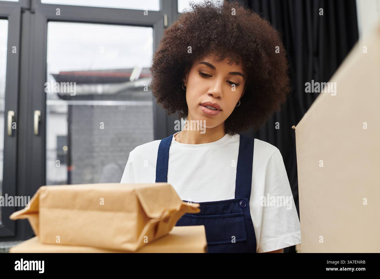 S’engager dans le processus méticuleux de tri des biens dans un espace de vie contemporain. Banque D'Images