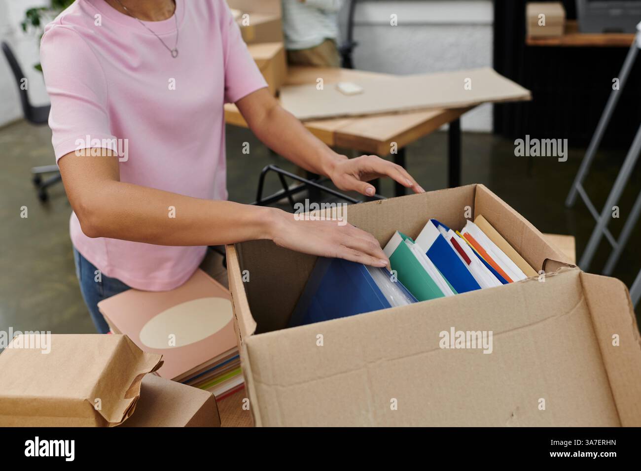 Emballer des fichiers colorés dans une boîte pour un déménagement de bureau en douceur dans un cadre moderne. Banque D'Images