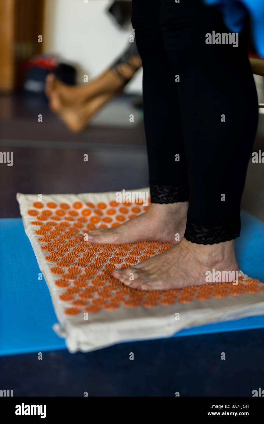Pieds debout sur un tapis d'acupression pour la relaxation et le soulagement de la douleur. Médecine alternative, réflexologie et concept de thérapie par acupuncture. Haute qualité p Banque D'Images