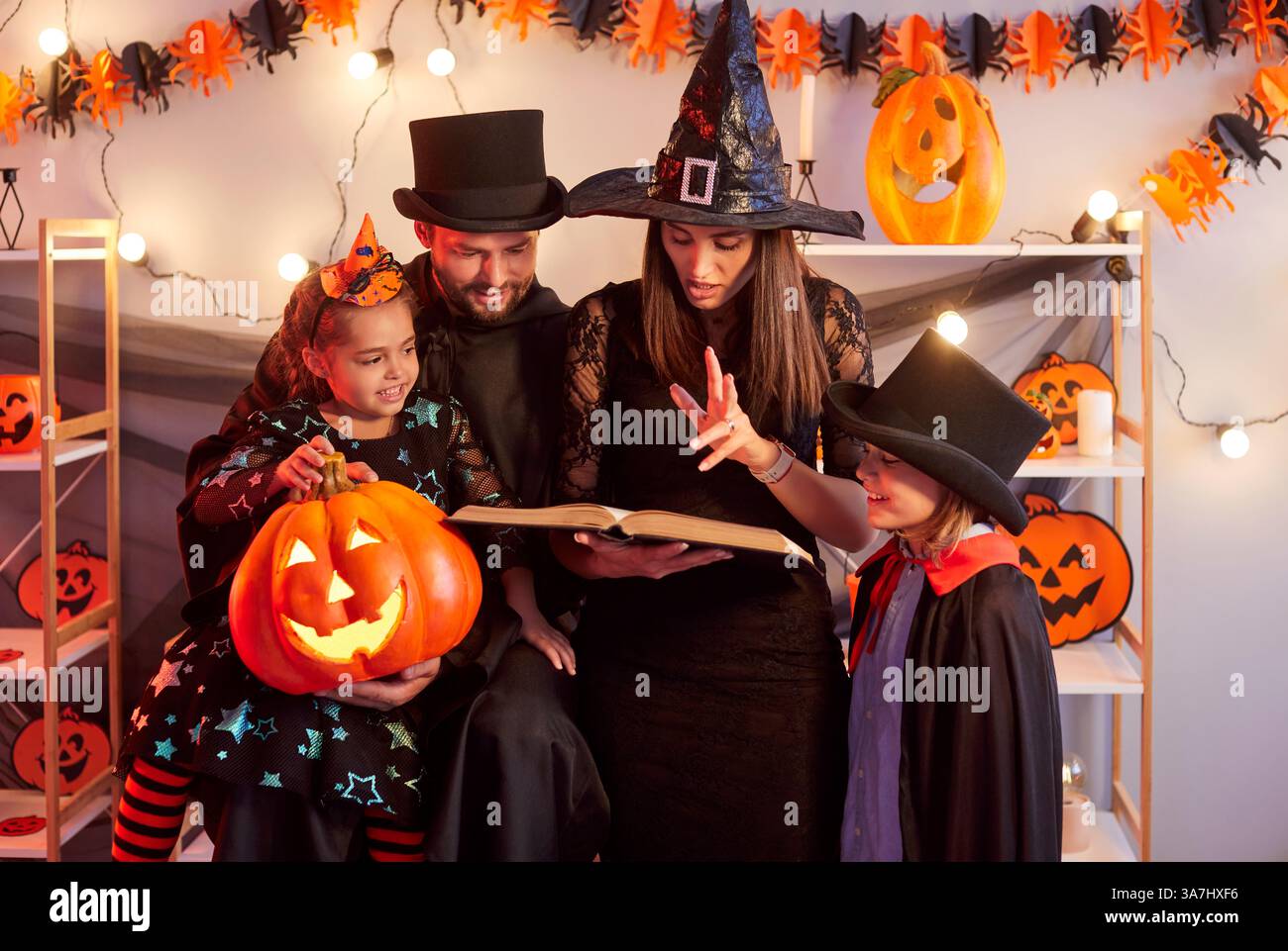 Amusement de vacances en famille d'Halloween, parents, enfants drôles avec lanterne de citrouille dans des costumes effrayants Banque D'Images
