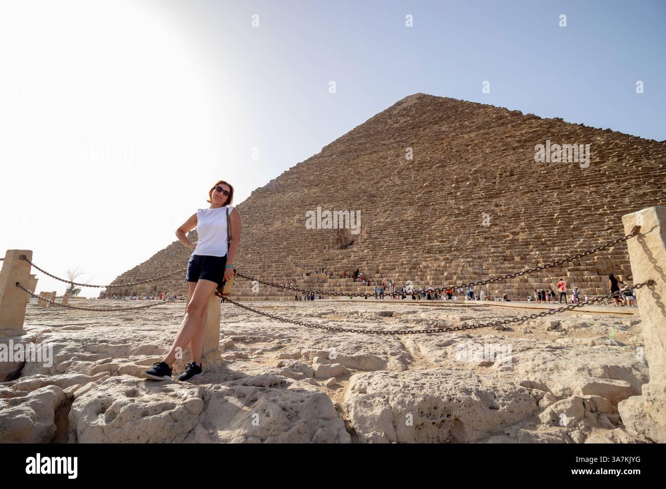 Une femme sur le plateau de Gizeh en Egypte, posant devant la Grande Pyramide. Concept de vacances et de voyage en Afrique. Banque D'Images