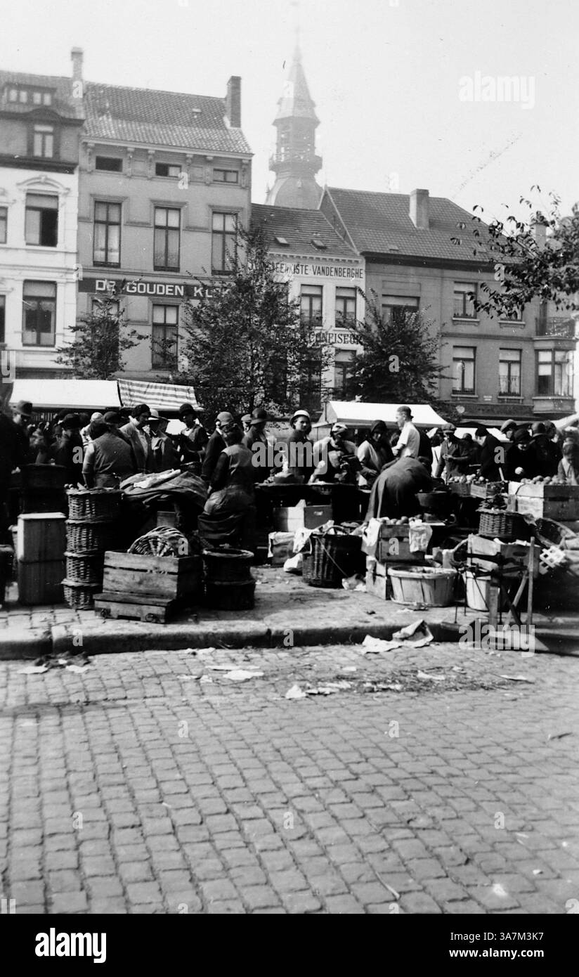 1932. Un marché de rue animé à Ostende, Belgique avec des bâtiments commerciaux en arrière-plan et une grande tour d'église derrière ceux-ci, pensé pour être la tour de Pierre, également connu sous le nom de Peperbusse. Cette tour est tout ce qui reste de l'ancienne église de Pierre, détruite par un incendie en 1896. D'une collection de photographies amateurs non attribuées dans la plage de dates, 1929-1936, qui comprennent les vacances britanniques et européennes. La plupart des images originales étaient d'environ 3 ½ x 2 pouces. Banque D'Images