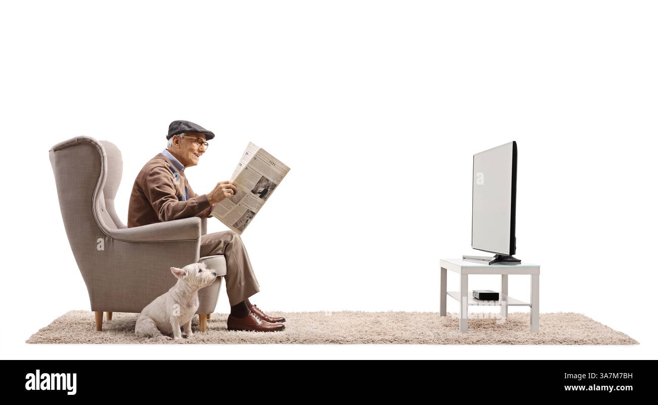 Homme âgé avec un chien assis dans un fauteuil avec un journal isolé sur fond blanc Banque D'Images