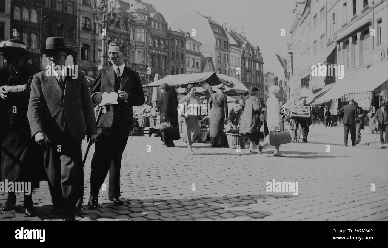 1936, histoire sociale et mode. Les gens sur la place du marché (Marktplatz) avec des stands et des bâtiments environnants. La Marktplatz est connue pour son atmosphère animée, ses marchés hebdomadaires, ses événements saisonniers et ses festivals. Il est entouré de cafés, de boutiques et de bâtiments historiques. D'une collection de photographies amateurs non attribuées dans la plage de dates, 1929-1936, qui comprennent les vacances britanniques et européennes. La plupart des images originales étaient d'environ 3 ½ x 2 pouces. Banque D'Images