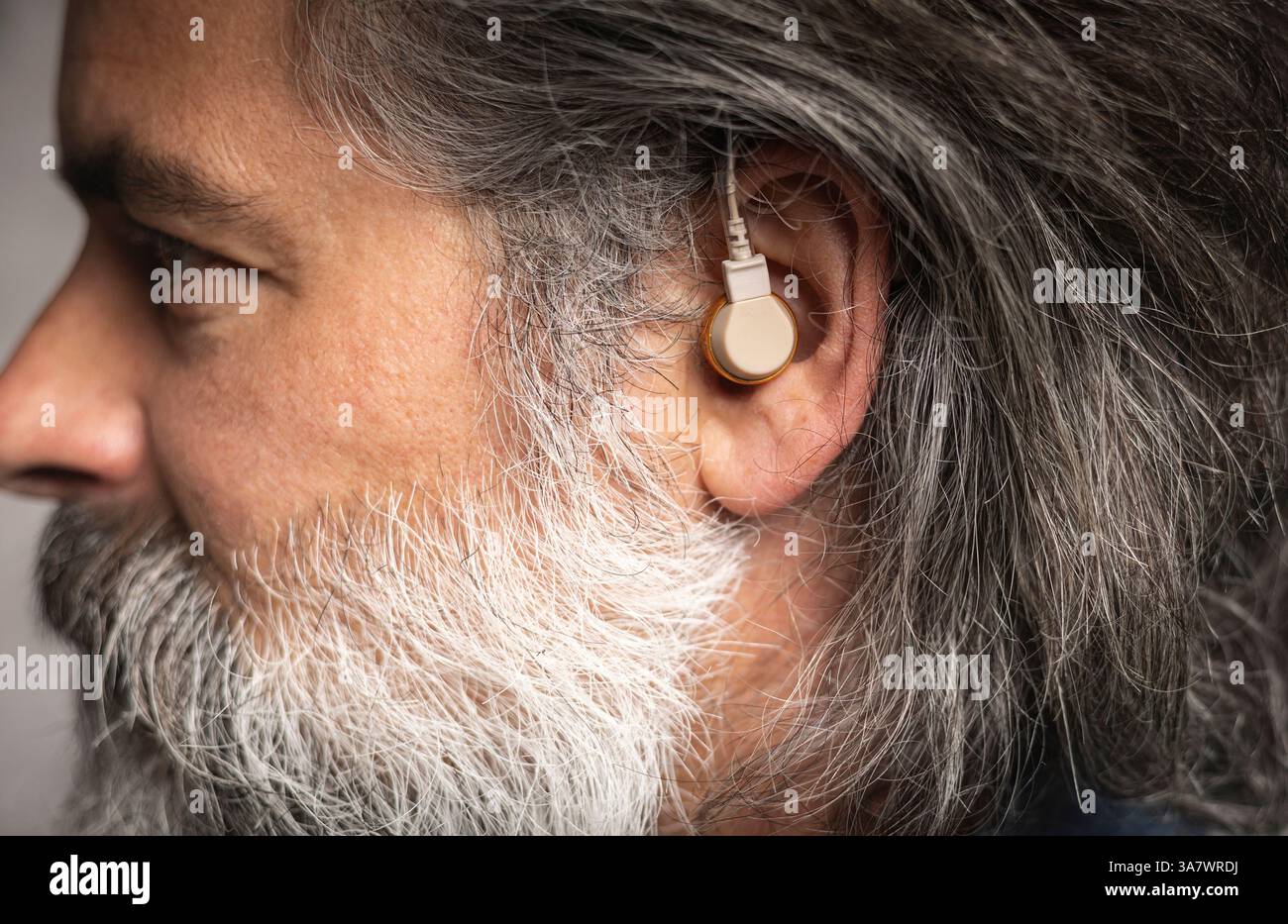 Prothèse auditive dans l'oreille d'un homme d'âge moyen Banque D'Images