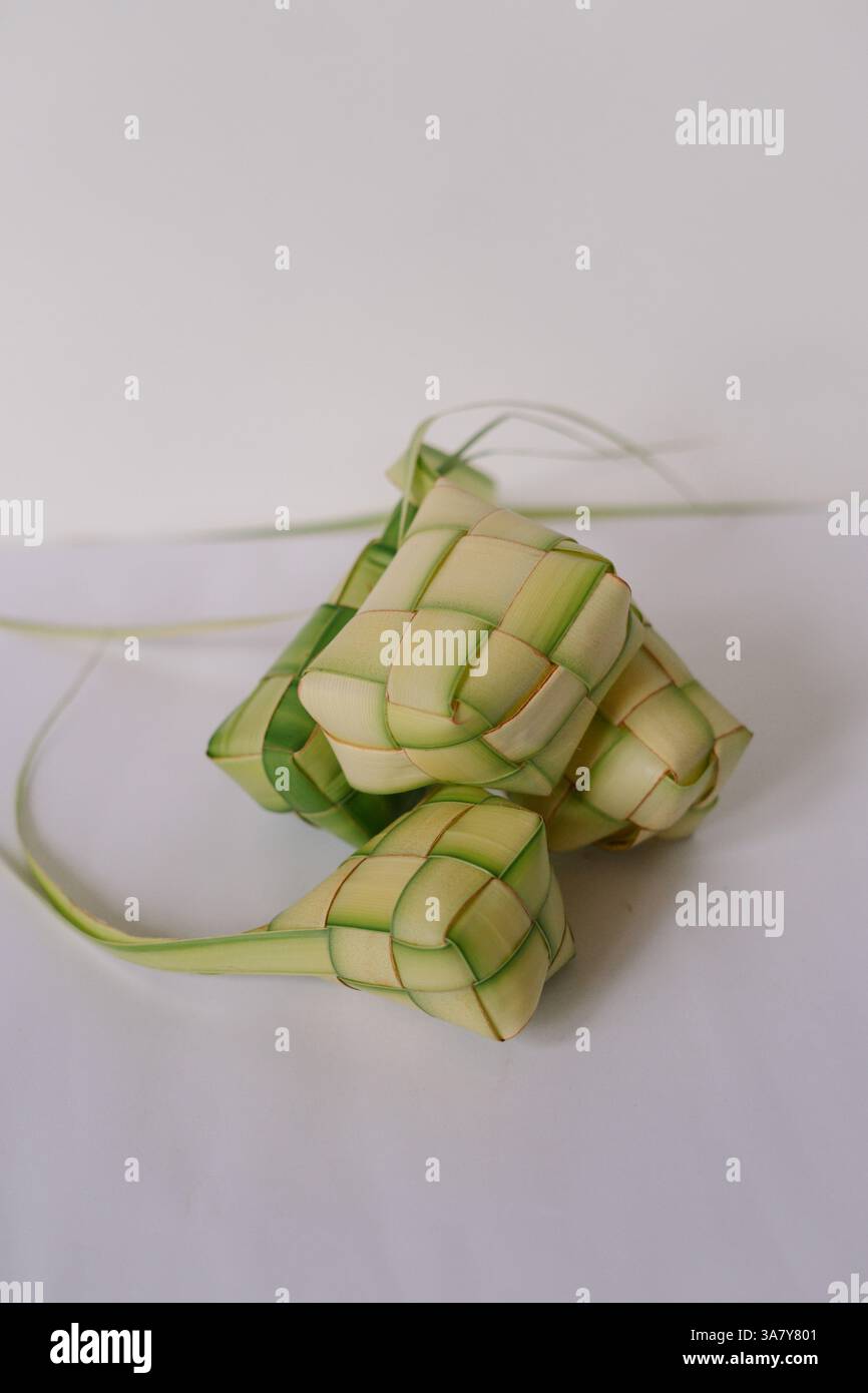 Gros plan sur le ketupat, gâteau de riz en forme de losange cuit dans des feuilles de palmier tissées, un plat traditionnel couramment servi pendant l'Aïd al-Fitr. Nourriture de fête, SY Banque D'Images