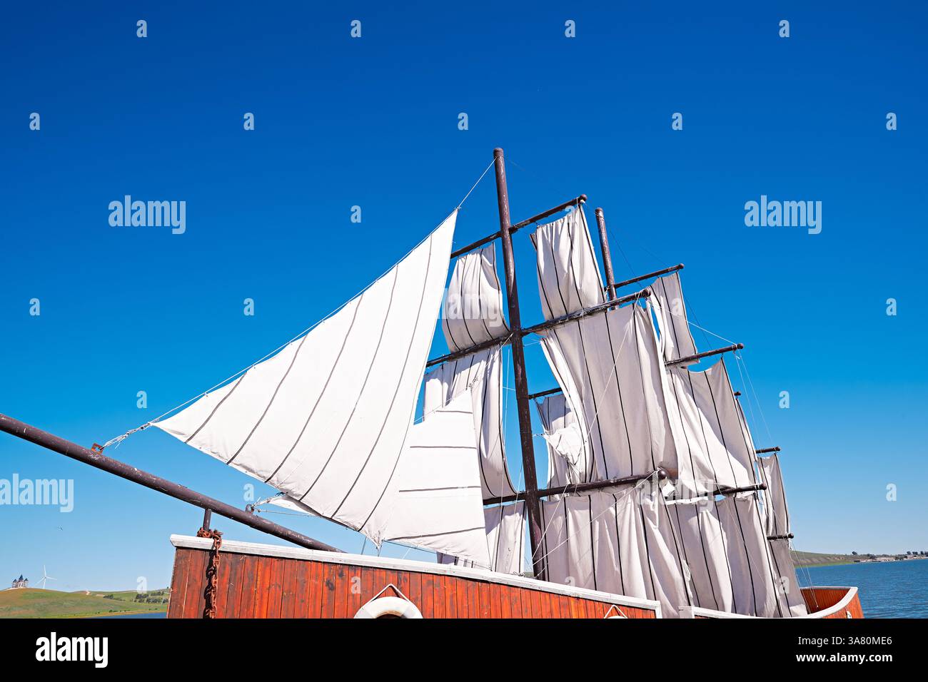 Voilier traditionnel avec voiles blanches sur l'eau calme Banque D'Images