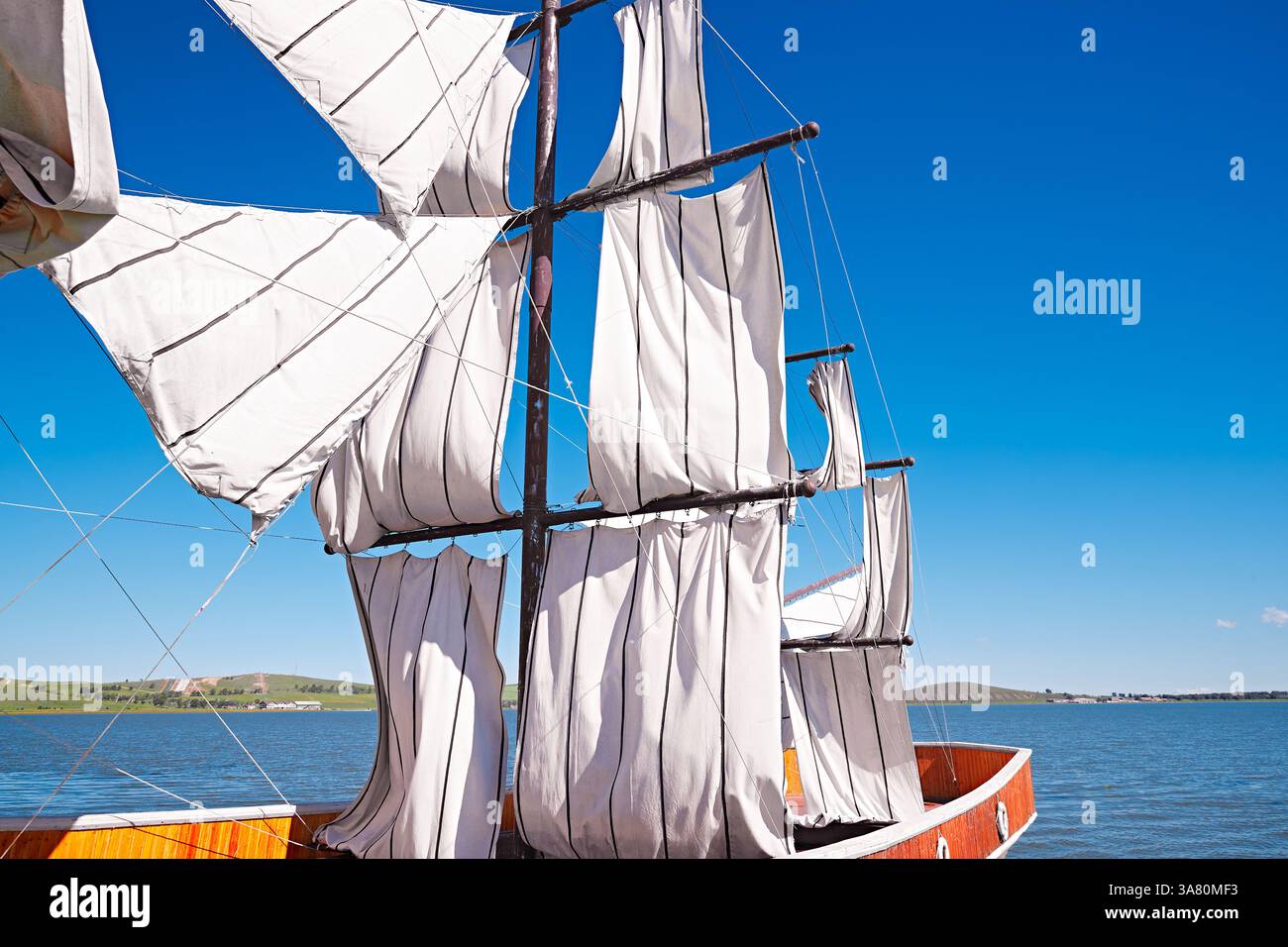 Voilier traditionnel avec voiles blanches sur l'eau calme Banque D'Images