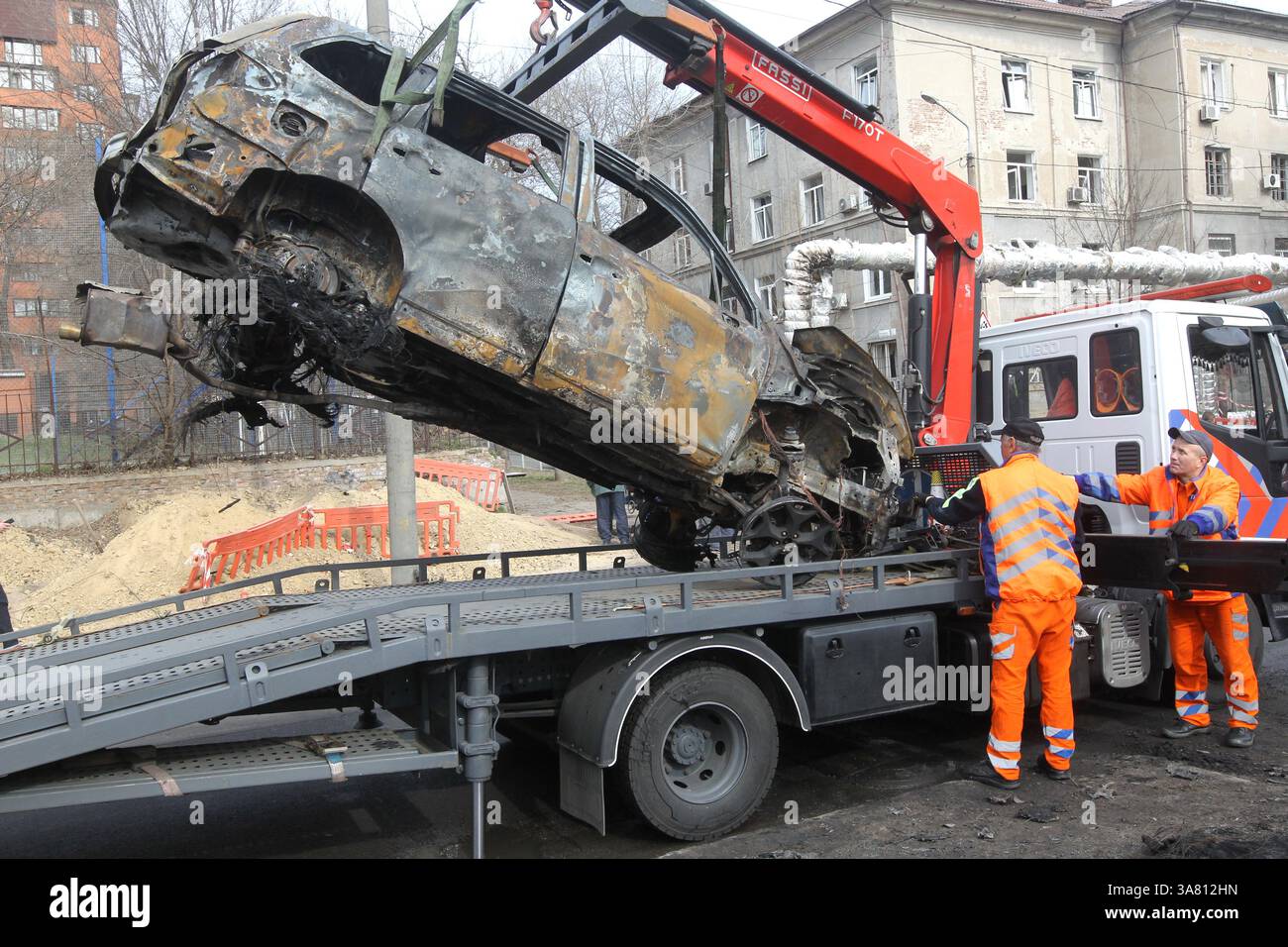 Des travailleurs de l’entreprise municipale “infrastructure de transport de la ville” évacuent des voitures détruites par une attaque de drone russe, Dnipro, Ukraine, le 27 mars 2025 (photo de Dmytro Smolienko/Ukrinform) Banque D'Images